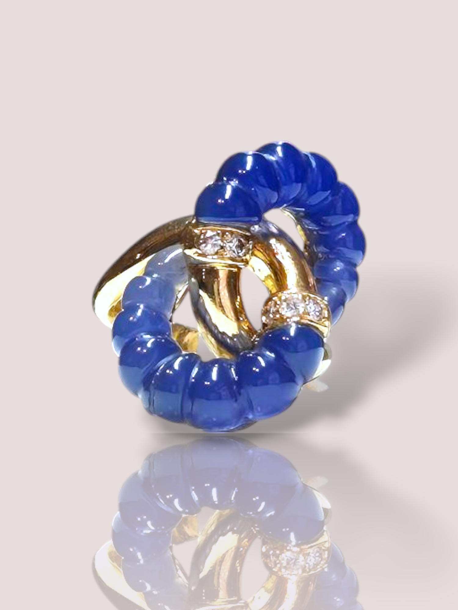 Deze prachtige vintage ring is gemaakt van 18k geel goud en is voorzien van chalcedoon en diamanten. De ring heeft een prachtige organische infinity vorm, waarbij de ring bezet is met glad geslepen chalcedoon met 6 schitterende witte briljant geslepen diamanten. Perfect voor een elegante en tijdloze uitstraling. 

Draag deze ring bij speciale gelegenheden of als een statement piece bij dagelijks gebruik. Combineer met andere gouden sieraden voor een harmonieuze look. Ideaal voor liefhebbers van unieke vintage-stukken.