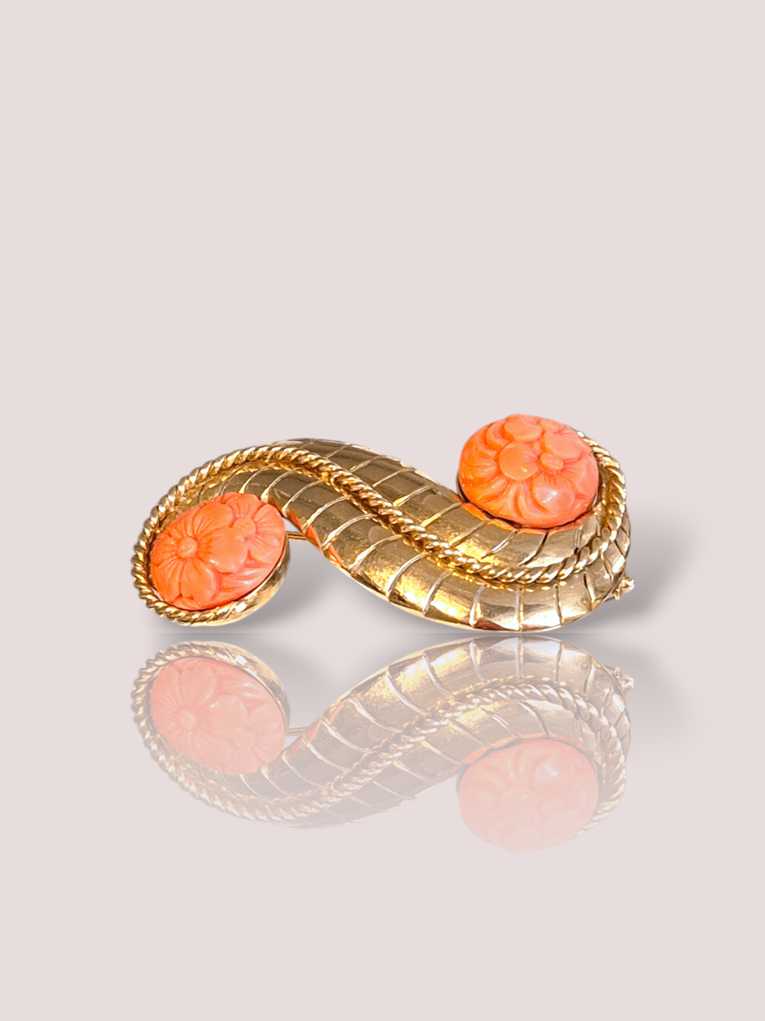 Deze prachtige vintage 18k geel gouden broche is versierd met bloedkoraal ornamenten, wat een klassieke en elegante uitstraling geeft. De broche is perfect voor het toevoegen van een vleugje glamour aan elke outfit. Draag hem op een colbert, blouse of jurk voor een verfijnde look. Deze broche is een tijdloos stuk dat perfect is voor elke gelegenheid.

De broche is 5 cm bij 2,5 cm en bevat bloedkoraal met een diameter van 1,4 cm waaruit een bloemenmotief geslepen is.