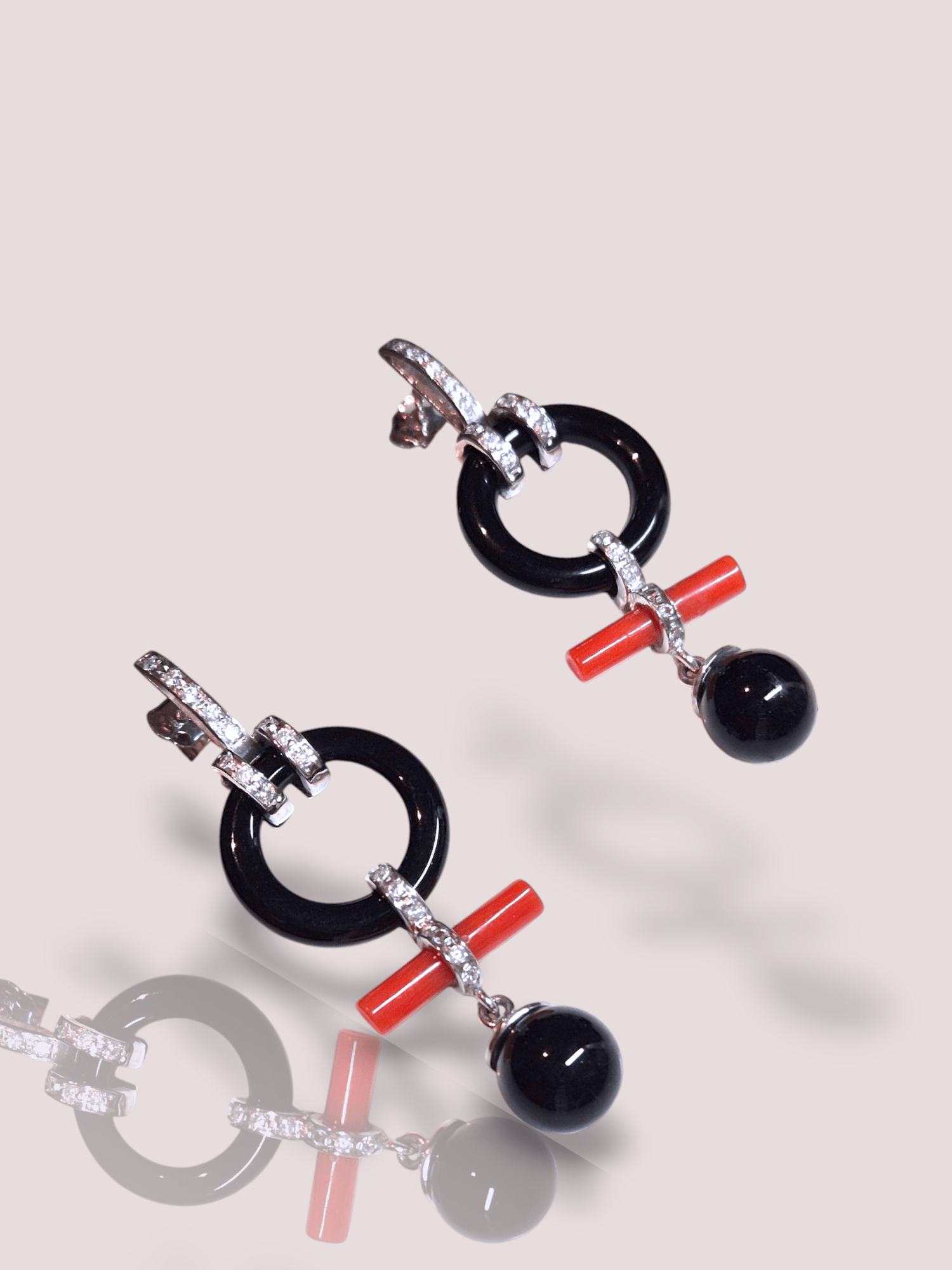Deze prachtige Vintage 18k witgouden oorbellen combineren de tijdloze elegantie van onyx met de schittering van diamanten. De hangers zijn 4,5 cm lang en hebben ook een stukje koraal in het midden en ze hebben elk 17 briljantjes van elk 0,015ct.

Perfect voor zowel formele als informele gelegenheden; draag ze met je favoriete outfit voor een verfijnde, stijlvolle look.