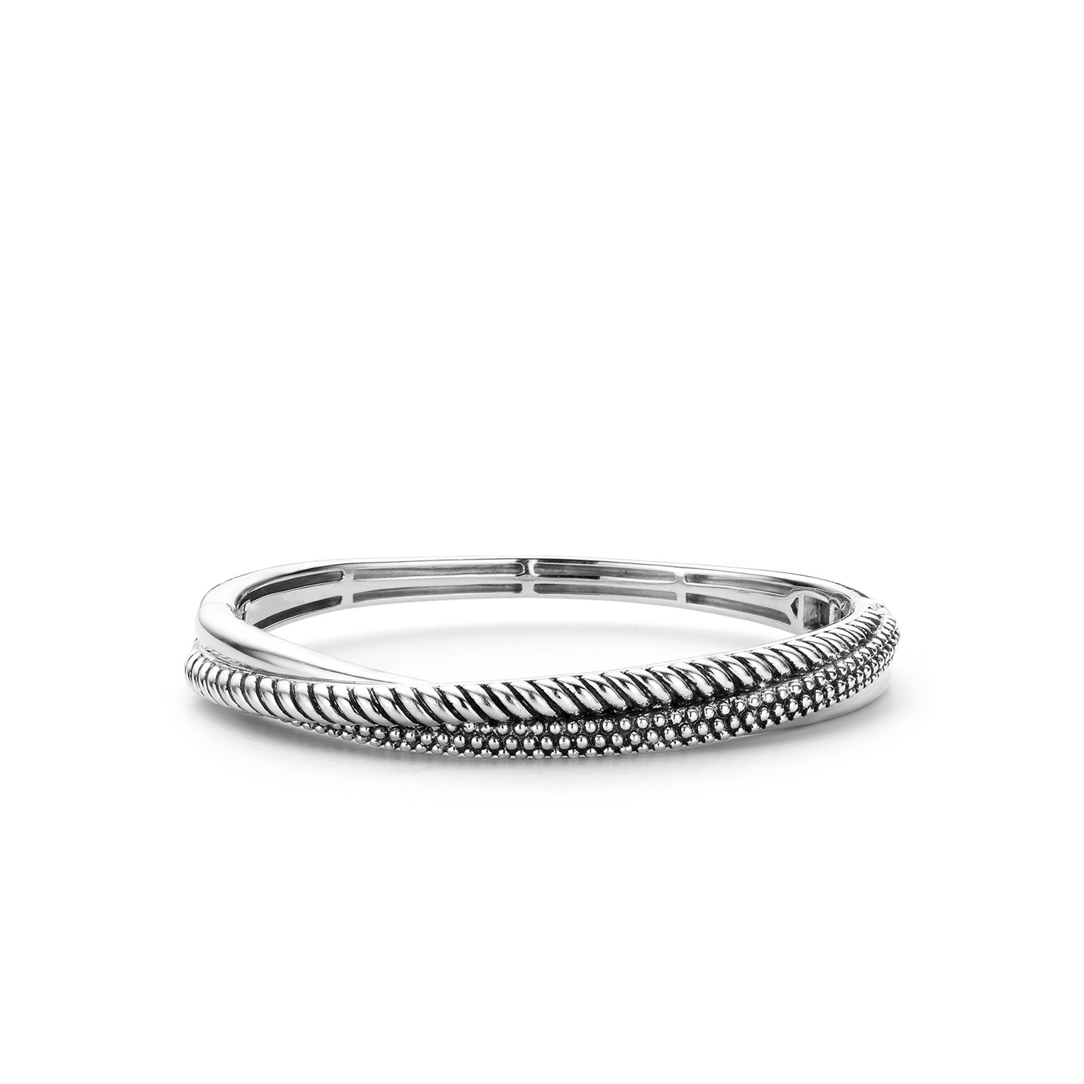 Zilveren structuren zijn een terugkerend kenmerk in de TI SENTO designs. Deze TI SENTO bangle van gerhodineerd sterling zilver is een combinatie van meerdere structuren. Een van de banden is glad gepolijst, de andere voorzien van gedraaid zilver en een laatste met ?bubble? structuur. De binnenzijde van de armband is voorzien van een printstructuur. Hierdoor is het sieraad licht om te dragen en drukt deze niet in de huid. Het ovale ontwerp draagt eveneens bij aan een comfortabele pasvorm. Het slot en scharnier zijn in het design weggewerkt.