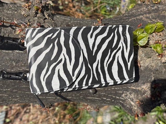 Deze BearDesign Patty telefoontas in het zebra is voorzien van een verstelbare schouderriem en heeft een handig voorvak voor extra opbergruimte. De tas kan gedragen worden als crossbody tas voor een trendy en praktische look. Perfect voor het meenemen van je telefoon en andere essentials tijdens een dagje uit of avondje uit. Met deze tas ben je altijd stijlvol en georganiseerd onderweg.

De meeste telefoons met hoes kunnen moeiteloos hierin worden opgeborgen.

Afmetingen:
Hoogte 20cm x breed 10cm x diep 3.5cm