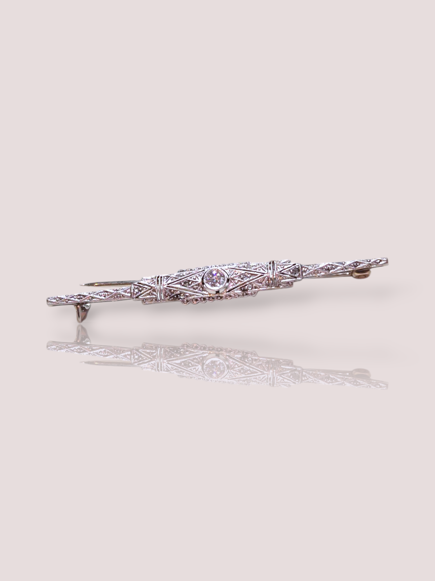 Deze prachtige 14k witgouden Art-Deco broche is bezet met een centrale fonkelende diamant van 0,20 karaat en heeft een elegant en tijdloos design. De broche kan gedragen worden op een colbert, jurk, sjaal of zelfs op een tas. De combinatie van het witgoud en de diamant zorgt voor een chique uitstraling die de perfecte finishing touch geeft aan elke outfit. Geef je look een vleugje glamour met deze schitterende broche! De broche is 6 cm breed en zorgt voor een elegante verschijning waar je ook komt.