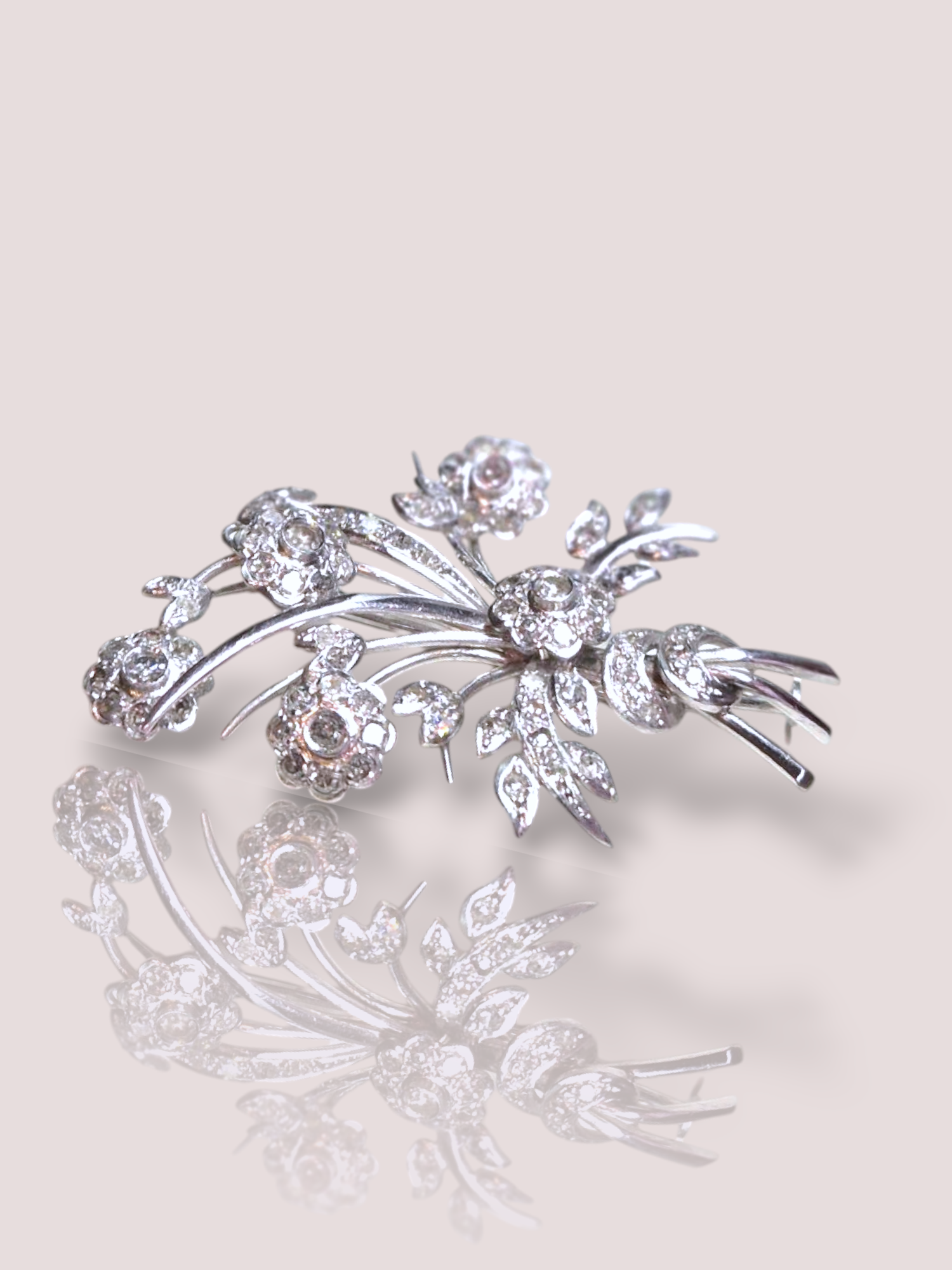 Deze prachtige vintage Art Deco broche is gemaakt van witgoud en platina en is bezet met schitterende diamanten. De broche heeft een tijdloos en elegant design dat perfect past bij elke outfit. Draag hem op een colbert, op een blouse of zelfs op een jurkje voor een extra vleugje glamour. Een absolute eyecatcher die je look compleet maakt! Ervaar de luxe en klasse van deze unieke broche.