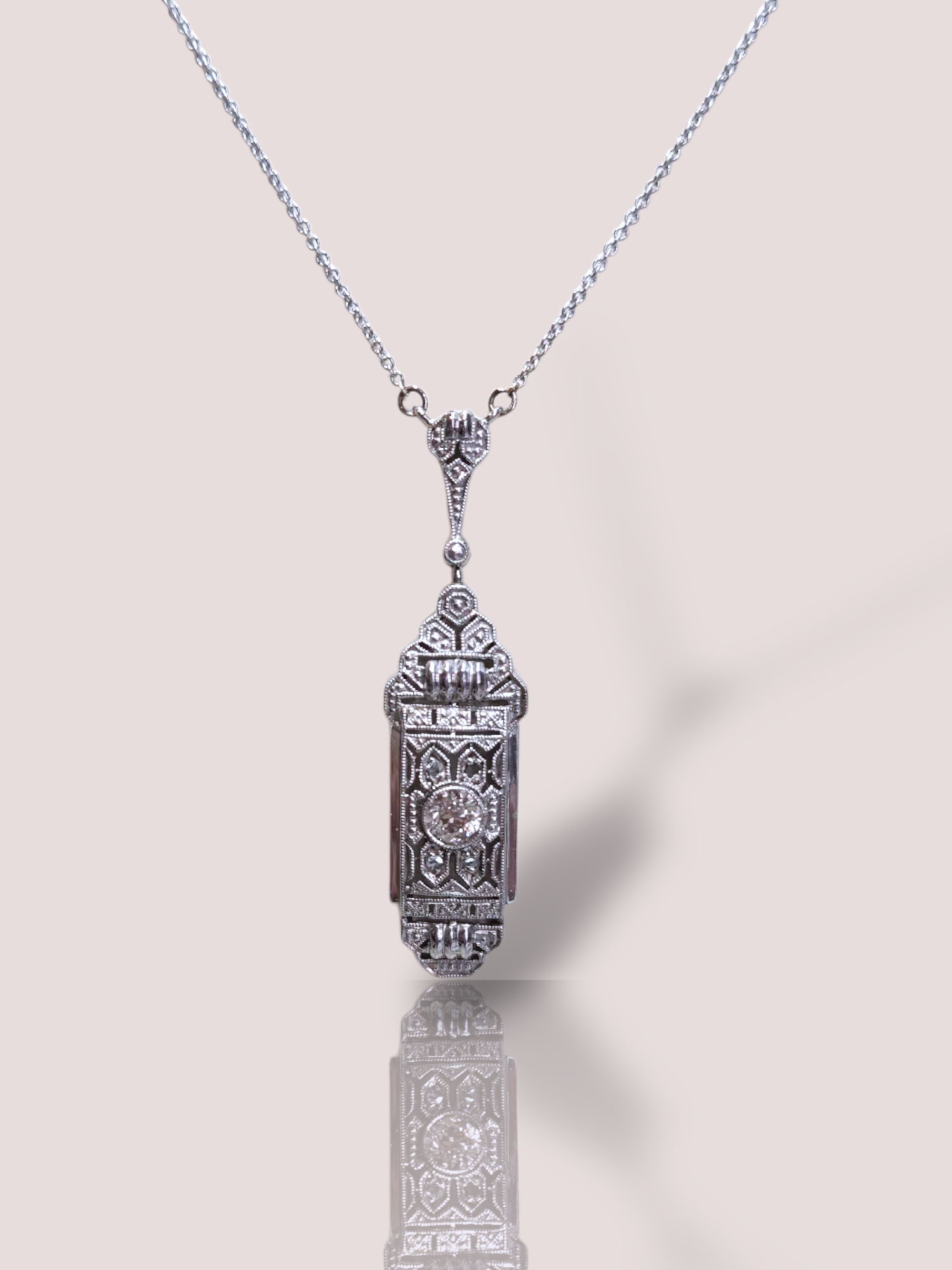 Dit antieke 14k witgouden collier heeft een prachtige hanger met Bolsjewiek geslepen diamant en roos geslepen diamanten. Gemaakt van witgoud, straalt deze ketting elegantie en verfijning uit. 

De grote diamant heeft een gewicht van circa 0,16ct en bevindt zich in een fraai en gedetailleerde bewerkte hanger. De hanger is 3,5 cm lang.

Perfect om te dragen bij formele gelegenheden of om een chique look te accentueren. Draag het met een eenvoudige jurk om de aandacht op de schitterende hanger te vestigen.