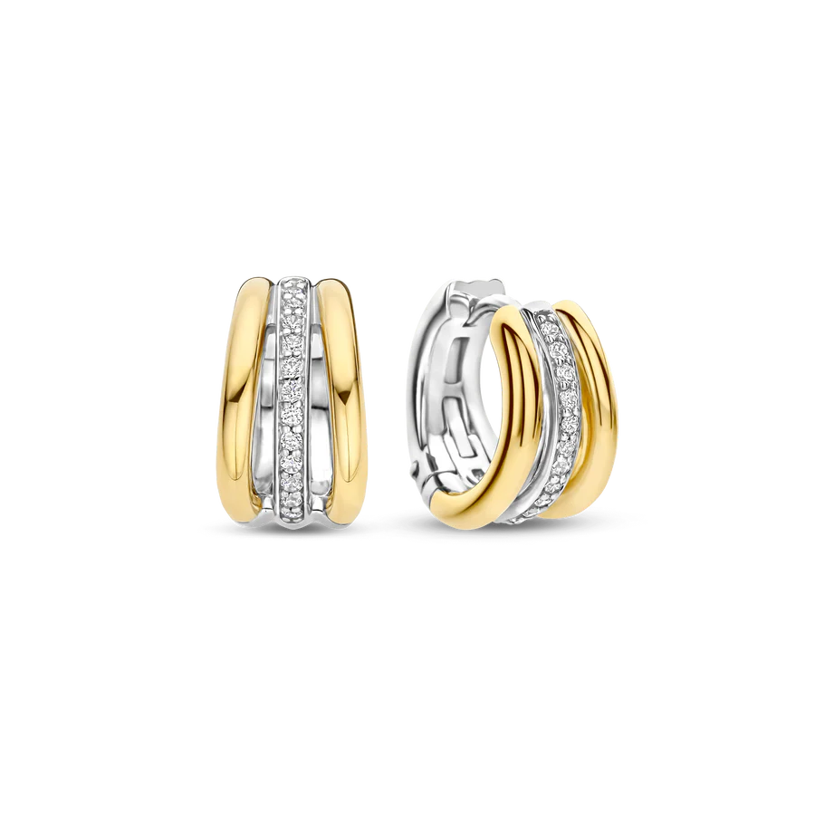 Deze TI SENTO oorbellen 78010ZY combineren diepte, contrast en schittering. Gemaakt van 925 sterling zilver, hebben ze een driedubbel hoepelontwerp: twee goudkleurige banden omarmen een platinakleurige hoepel met pavé gezette cubic zirconia. Deze oorbellen voegen een elegante touch toe aan elke outfit. De veilige scharnier sluiting zorgt voor comfort, waardoor ze de hele dag gedragen kunnen worden. Nikkelvrij en hypoallergeen voor luxueus comfort. Een mix van gouden warmte, ijzige schittering en eigentijds design, perfect voor elke gelegenheid.
