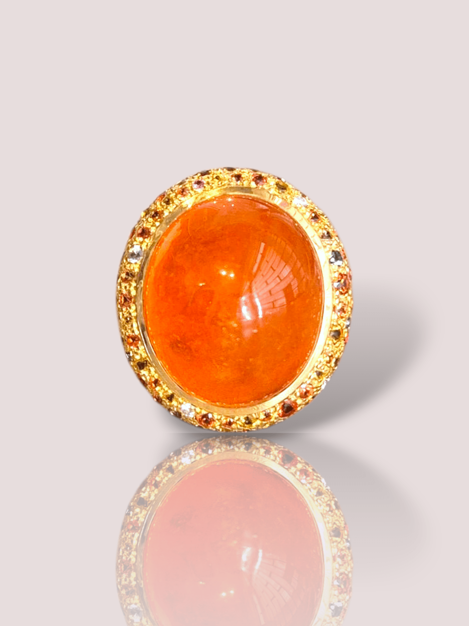 Deze vintage 18k geelgouden statement ring heeft een prachtige levendige oranje cabochon geslepen granaat als center stone. Deze steen is omringd door diverse delicate saffieren en diamantjes in verschillende kleuren. Perfect voor speciale gelegenheden. 

Combineer het met een klassieke zwarte jurk of een stijlvol avondensemble voor een opvallende look. Deze ring voegt een vleugje verfijning toe en is een must-have voor elke sieradenliefhebber.

De afmeting van de ring is 2,2 bij 2,5 en weegt 41,70 gram.