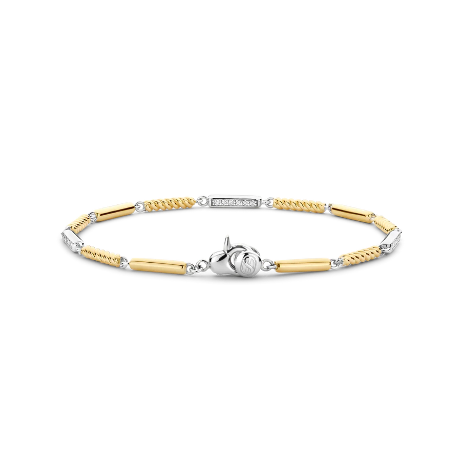 De TI SENTO armband 23069ZY verrijkt je elegantie met een stralende combinatie van luxe materialen en tijdloos design. Deze armband heeft afwisselend sterling zilveren schakels en vergulde schakels, waarvan sommige zijn verfraaid met delicate pavé-set cubic zirconia accenten, terwijl andere een speelse touwstructuur tonen. De armband is vervaardigd uit premium 925 sterling zilver en verguld. Perfect in lijn met de gloed van warme zomerdagen, voegt dit stuk verfijning en sprankeling toe aan elk ensemble. Of je nu geniet van een zonnige middag of een glamoureuze avond, de uitstekende afwerking en het harmonieuze ontwerp maken het een veelzijdig accessoire. Hypoallergeen en nikkelvrij, zorgt deze armband voor langdurig comfort en biedt blijvende kwaliteit.