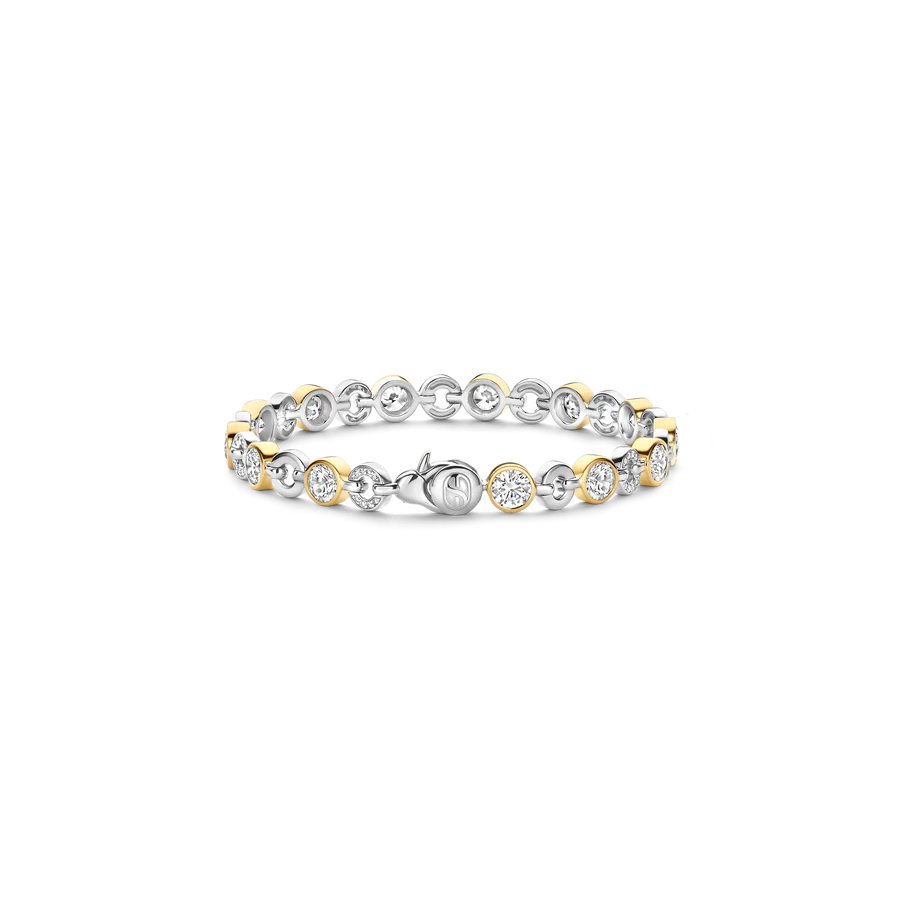 Tijdloze elegantie ontmoet eigentijds vakmanschap in deze klassieke TI SENTO armband 23054ZY. Vakkundig vervaardigd uit premium 925 sterling zilver, biedt dit sieraad een verbluffend samenspel van gouden- en zilvergekleurde tinten. Bezelgezette cubic zirconia stenen stralen schittering uit, afwisselend tussen luxe vergulde accenten. Het verfijnde schakelontwerp voegt een vleugje verfijning toe, terwijl de fonkelende stenen een glamoureuze glans aan je pols brengen. Of je nu gekleed gaat voor een verfijnde avond of je dagelijkse stijl wilt verfraaien, deze armband is een veelzijdig meesterwerk dat zich aan elk moment aanpast. Combineer het met bijpassende TI SENTO sieraden voor een gecoördineerde look, of laat het solo schitteren als een statement van moeiteloze gratie. Nikkelvrij en hypoallergeen, het zorgt voor comfort en blijvende schoonheid.
