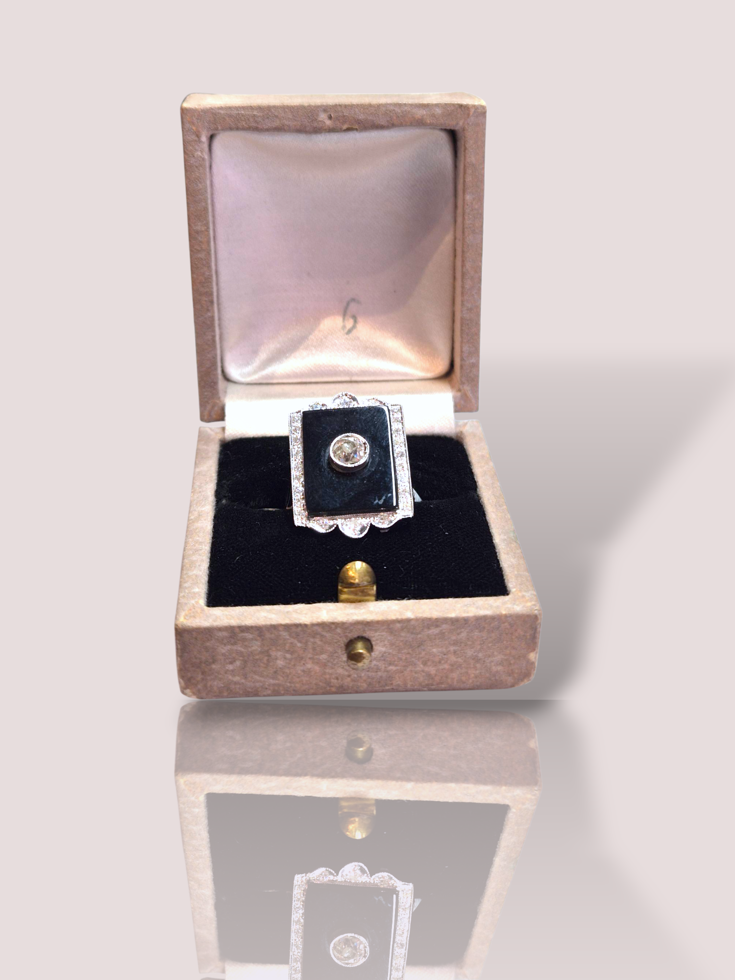 Deze vintage Art Deco 18k witgouden ring met diamanten en onyx straalt pure elegantie uit. De ring heeft een prachtig ontwerp met een glinsterende diamant in het midden, een diepzwarte onyx steen en een omlijsting met diamanten. Draag deze ring als een statement piece voor een luxe uitstraling. Combineer het met andere gouden sieraden voor een complete look. Een tijdloos stuk dat perfect past bij elke gelegenheid. De ring kan op maat gemaakt worden. De onyx is 1,6 bij 1,2 cm. De totale hoogte van de ring is 2,3 cm