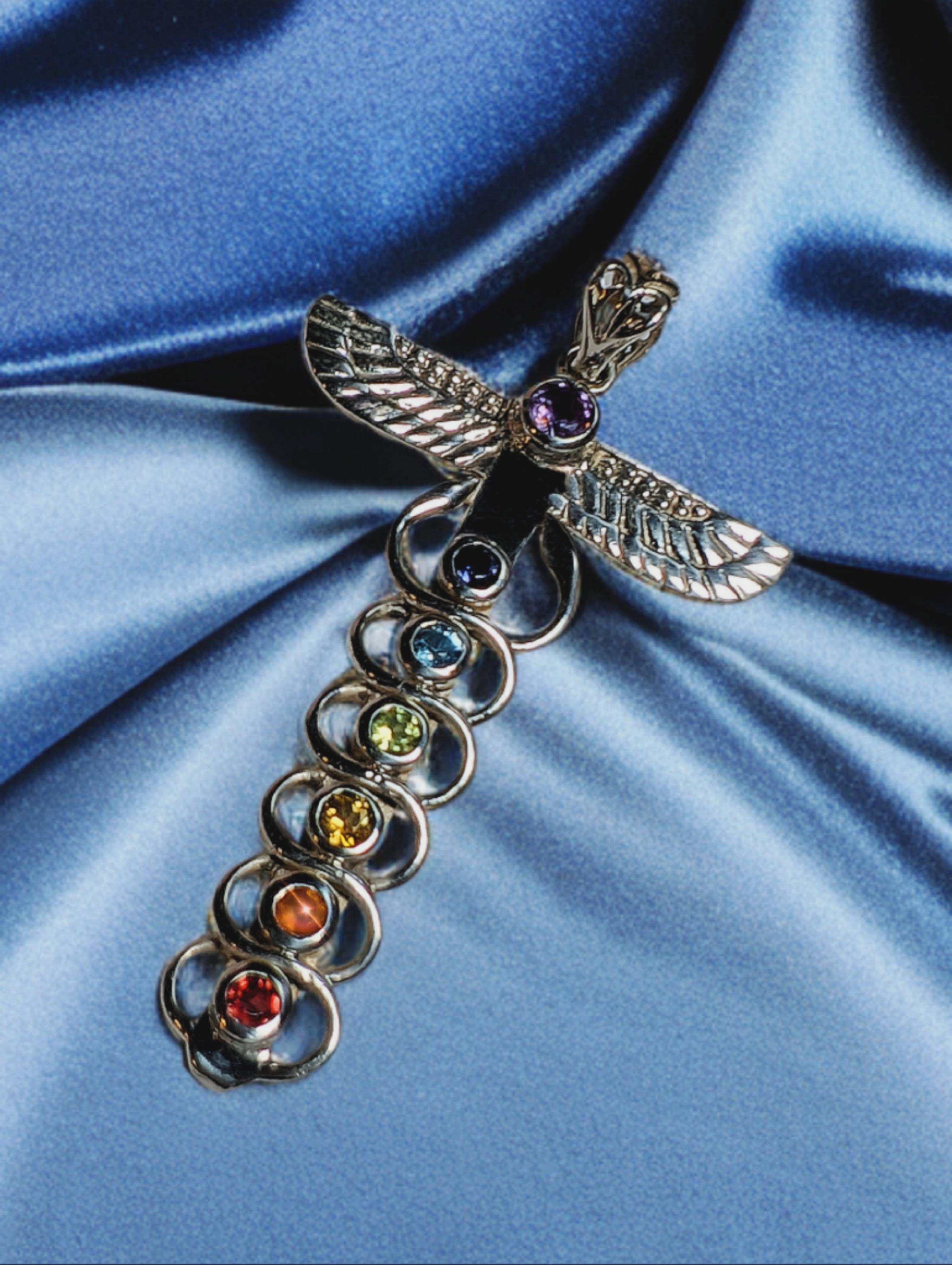 925 Sterling Zilveren hanger met natuurstenen in de kleren van alle chakra's.
De hanger heeft de vleugels van de Egyptische godin Isis en 2 esculaap slangen. 