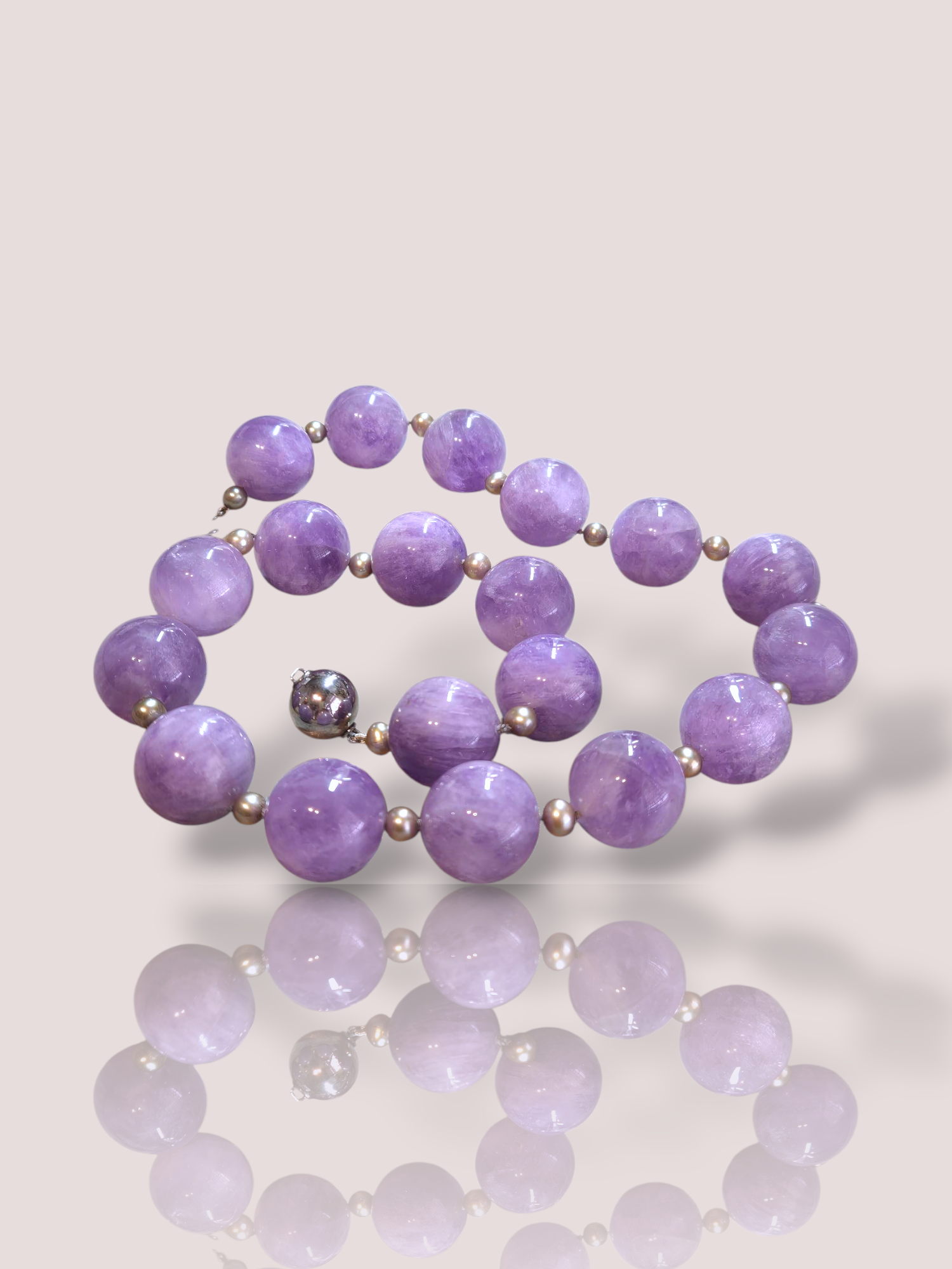 Dit prachtige vintage amethist kralencollier met parels en een zilveren slot is een uniek sieraad. Dit bicolor collier combineert elegantie en stijlvol design. Het is perfect om te dragen bij zowel formele als informele gelegenheden voor een verfijnde uitstraling. Voeg een vleugje luxe toe aan elke outfit.

Er zijn 18 amethist kralen van elk 1,8 cm dik, afgewisseld met 20 prachtige zoetwaterparels.