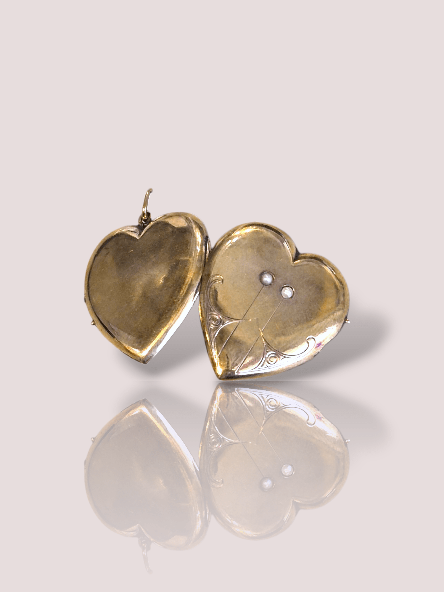 Dit prachtige Art-Deco 14k geel gouden medaillon is versierd met kleine pareltjes voor een elegante uitstraling. Het medaillon is 27 mm breed en 29 mm hoog. Draag het medaillon dicht bij je hart aan een fijne gouden ketting voor een tijdloze look. Laat het medaillon schitteren als statement piece of combineer het met andere gouden sieraden voor een stijlvolle en verfijnde uitstraling. Maak je look compleet met dit unieke en klassieke medaillon. Het medaillon kan open en er kan een foto in geplaatst worden. 