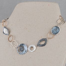 Collier uit de Touch of Gold-collectie van Jeh Jewels, gemaakt van 925 sterling zilver met hoogglans, geoxideerd zilver en een laagje Goldfilled. Dit collier bestaat uit verschillende organische vormen, wisselend van materiaal. Dit collier doet ons denken aan een dagje relaxen op het strand, stylish en bohemian!