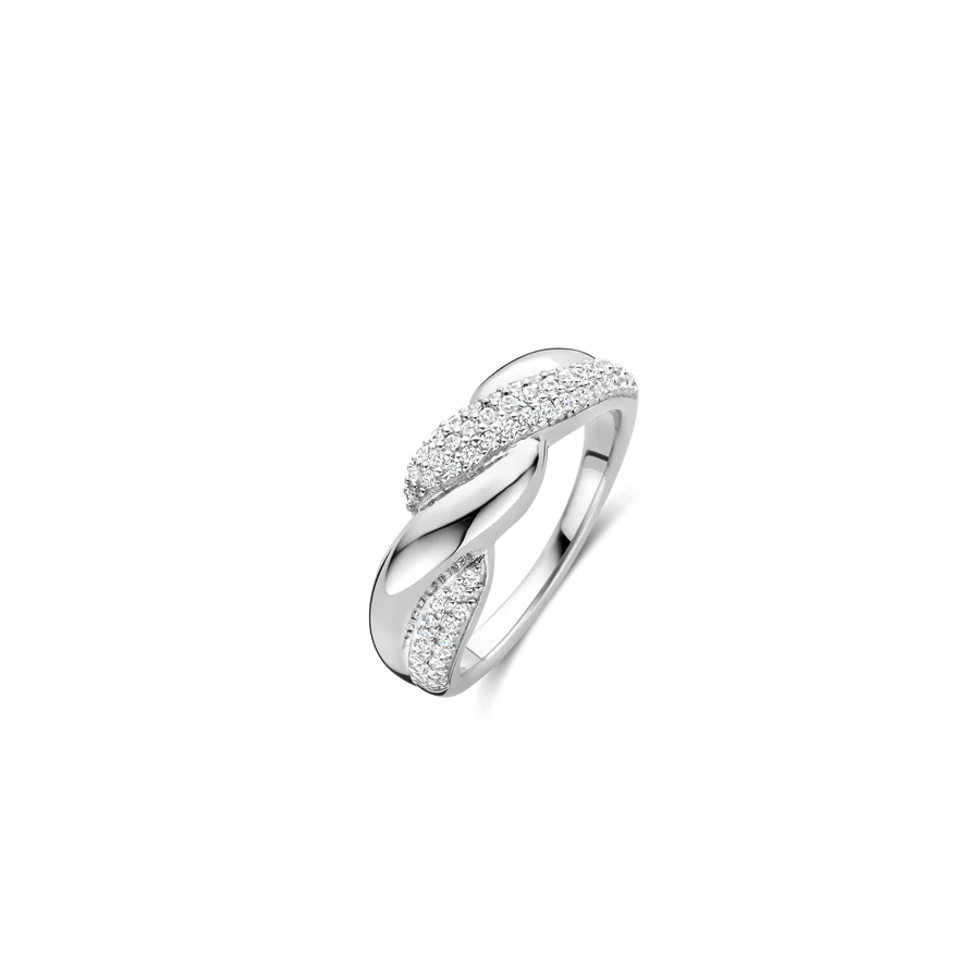 Laat je vinger omhuld worden door de liefdevolle omarming van deze gedurfde TI SENTO zilveren ring 12370ZI, een ontwerp dat de schoonheid van verbinding belichaamt. Vervaardigd uit hoogwaardig 925 zilver en platinagkleurd voor blijvende schittering, heeft dit opvallende stuk twee verstrengelde banden. De ene band schittert met de strakke eenvoud van gepolijst zilver, terwijl de andere fonkelt met een prachtige pavé van zirkonia stenen. Gedurfd maar gracieus, deze ring is een symbool van eenheid en balans, waardoor het het perfecte accessoire is om elke outfit te verfraaien. Of het nu wordt gedragen om een statement te maken of gecombineerd met andere TI SENTO stukken, het is een betoverende toevoeging aan je sieradencollectie. Zorgvuldig vervaardigd voor de gevoelige huid, deze nikkelvrije en hypoallergene ring garandeert langdurig comfort en kwaliteit.
