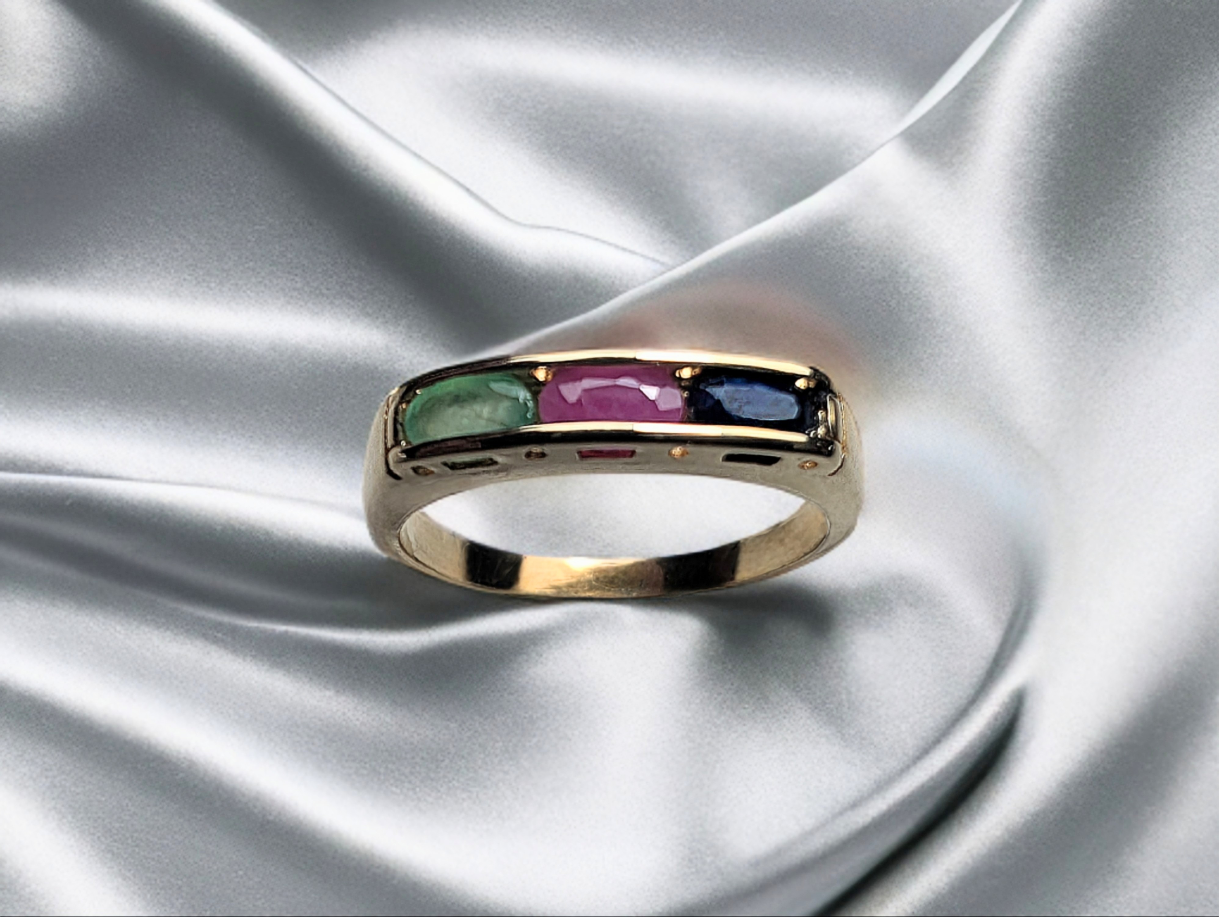 14 Karaat Geel Gouden Vintage Railzetting Ring met Ovaal Geslepen natuurlijke Smaragd, Robijn en Saffier. 

De ring en steen hebben lichte draagschade, maar zijn; ultrasonisch gereinigd, gepolijst en de zetting is zo goed als mogelijk nagekeken.

Op Vintage ringen kunnen wij maar een beperkte garantie geven. 
Dit omdat wij niet de exacte geschiedenis en fabricatie methode van de ring kunnen weten.