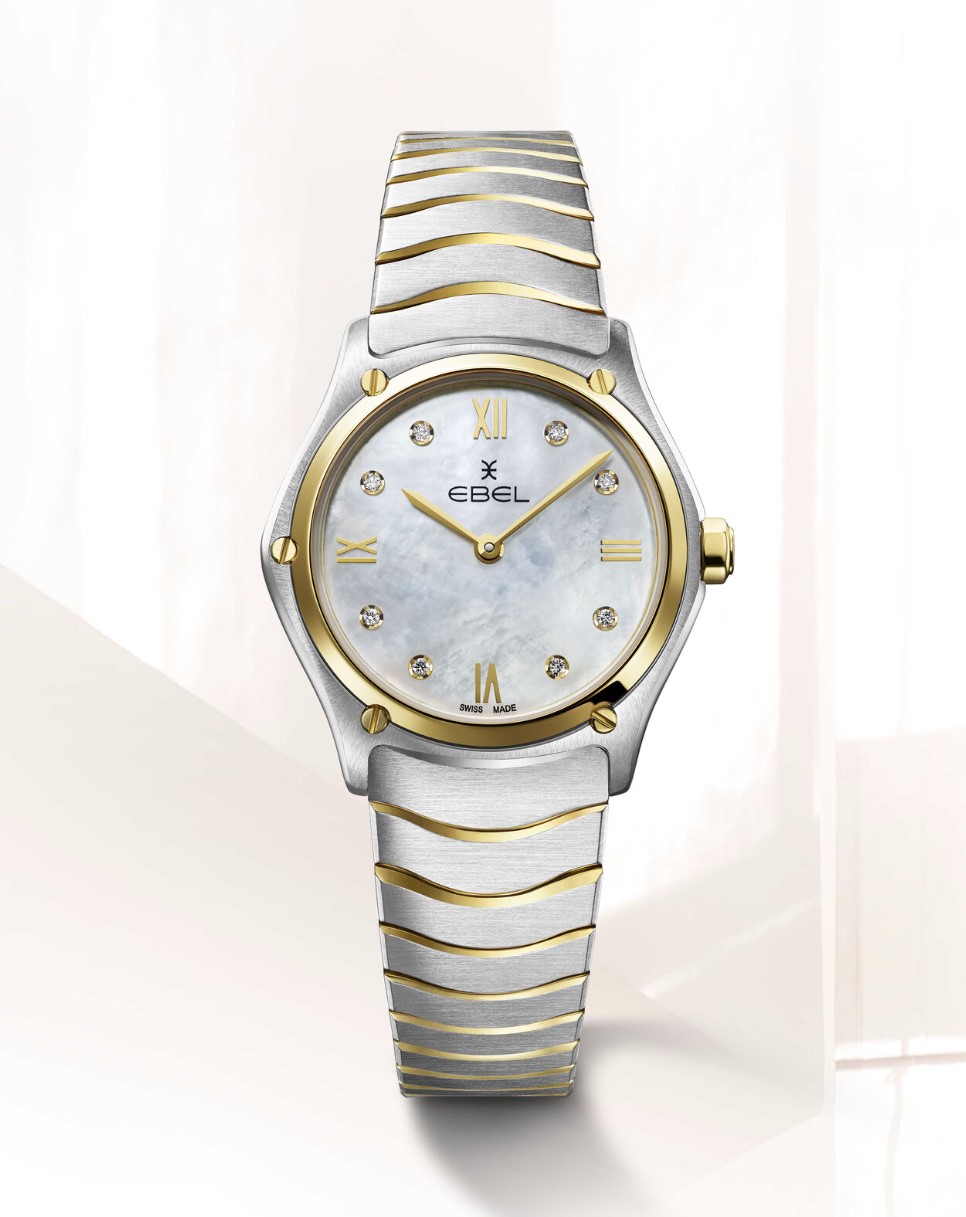EBEL Sport Classic - 1216388A dames pols horloge. Edelstalen kast gecombineerd met 18 karaat geel goud. Ø 29 mm. Witte parelmoeren wijzerplaat met Romeinse cijfers en 8 diamanten ( 0,052 crt ). Ontspiegeld Saffier glas. Edelstalen Wave band met goud accenten en klap sluiting. Zwitsers quartz uurwerk. 5 ATM waterdicht.