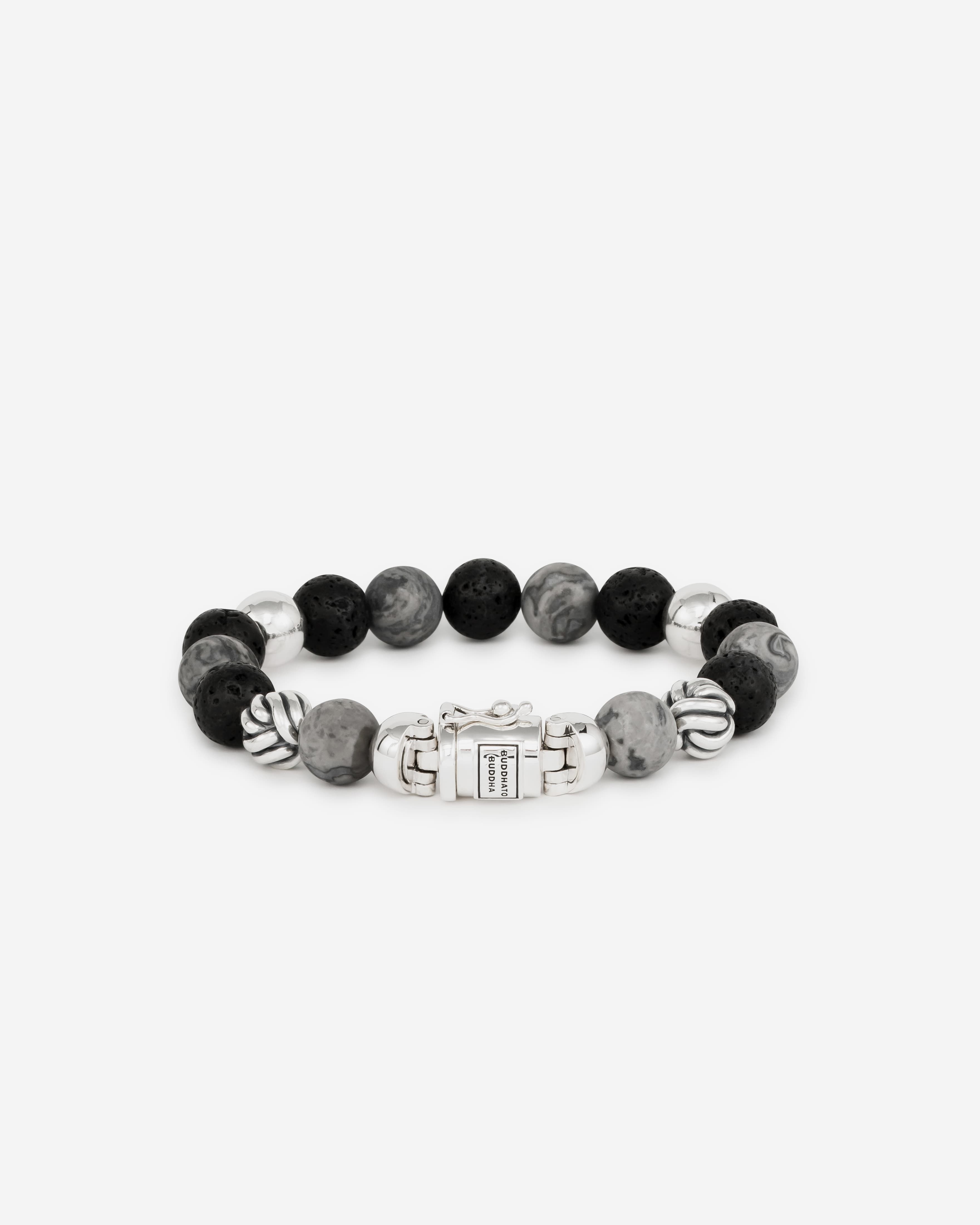 De Spirit Bead Mix grijze Picasso Jaspis-armband is gebaseerd op bidkralen en is vertaald naar een Buddha to Buddha ontwerp met zijn iconische sterling zilveren slot. We omarmen de edelsteenkralen vanwege hun schoonheid en spirituele betekenis. Deze armband heeft grijze Picasso-jaspisstenen afgewisseld met zwarte lavastenen. Jaspis heeft sterke aarding en kalmerende eigenschappen die helpen om kracht en zelfdiscipline aan te moedigen en lava-stenen kalmeren de emoties. De armband is handgemaakt en tijdloos zoals al onze sieraden en kan gemakkelijk worden gecombineerd met leren of zilveren stukken.

Let op: het slot van deze Spirit bead armband bevat een magneet. Deze is niet roestvrij en daarom belangrijk om elk contact met water te vermijden (zoals zwemmen & douchen etc.) om optreden van roest rondom de magneet te voorkomen.
