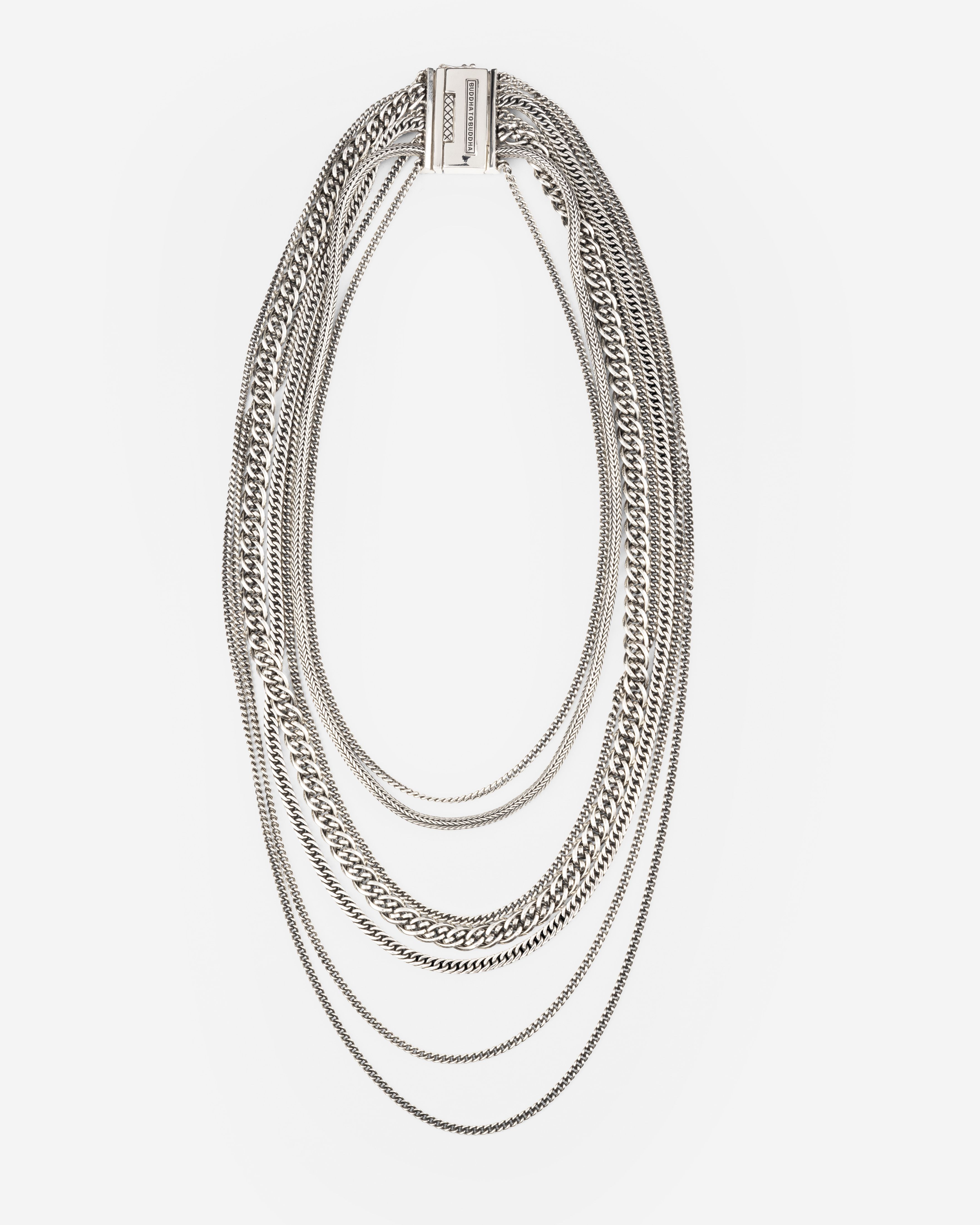 640Nathaliemultichain75. 
Deze ketting bestaat uit 7 kettingen in één en heeft dezelfde stijl als onze Multi Chain ring en armband. Hij bestaande uit onze iconische Esther, Nathalie en Ellen designs en 4 Essential kettingen. Met een klassieke brede sluiting en een iconische Buddha to Buddha ontwerp, past het perfect bij onze andere sieraden. Deze hoogwaardige ketting is echt uniek en laat jou de show stelen op iedere speciale gelegenheid.