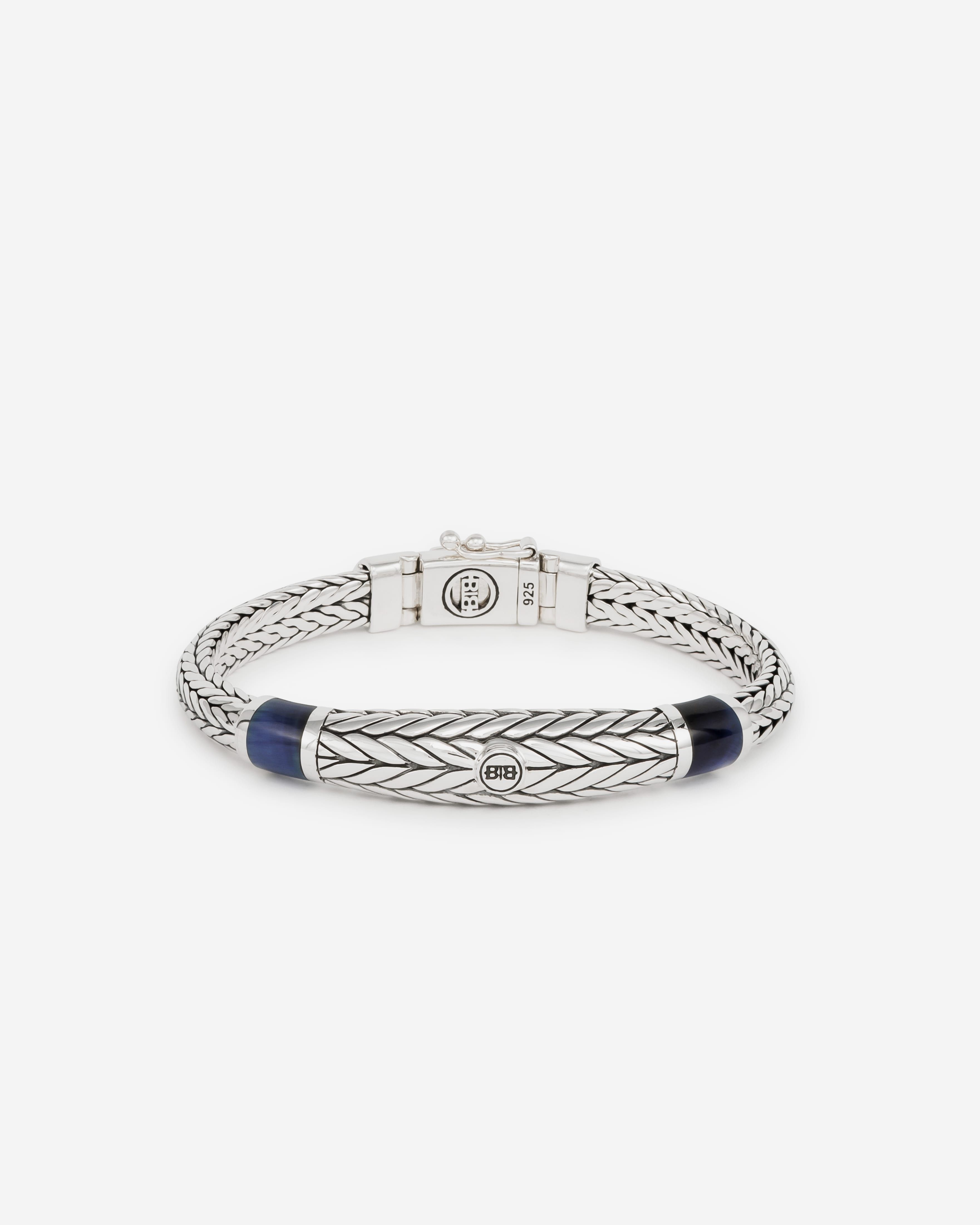 Buddha to Buddha armband, J152 E Ellen XS

Ontdek de elegantie en kracht van de Ellen XS Stone Bracelet. Deze prachtige armband heeft een opvallende tijgeroog steen met een kenmerkende marineblauwe kleur, waardoor het een uniek en opvallend accessoire is. De blauwe tijgeroogsteen is een symbool van kracht. Het roept moed op, verdiept de wilskracht en helpt degenen die het dragen om allerlei uitdagingen in hun leven te overwinnen. De zilveren armband heeft een dikker middenstuk dat de Ellen-schakel benadrukt. Elk stuk wordt met de hand gevlochten op basis van een traditionele Aziatische vlechttechniek.