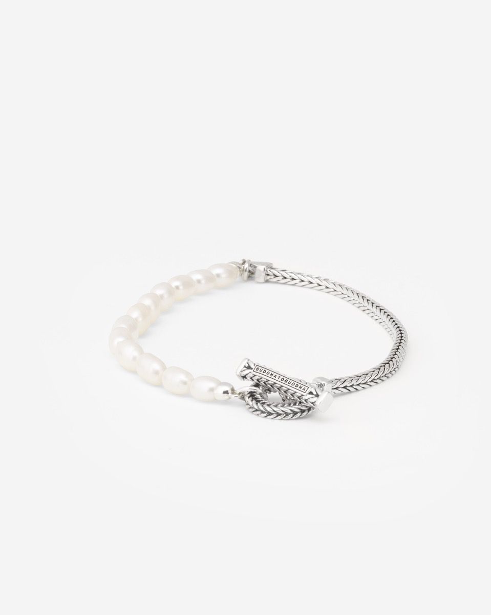 De Barbara Parel armband biedt een unieke mix van witte gekweekte ovale zoetwaterparels, gecombineerd met de kenmerkende Barbara schakel en afgewerkt met een getextureerde toggle sluiting. Dit tijdloze design is geschikt voor iedereen en kan moeiteloos worden gecombineerd met andere items uit de Buddha to Buddha collectie. Met wie verbind jij je door het dragen van deze armband? Laat jouw persoonlijke verhaal zich vervlechten met dit unieke sieraad.