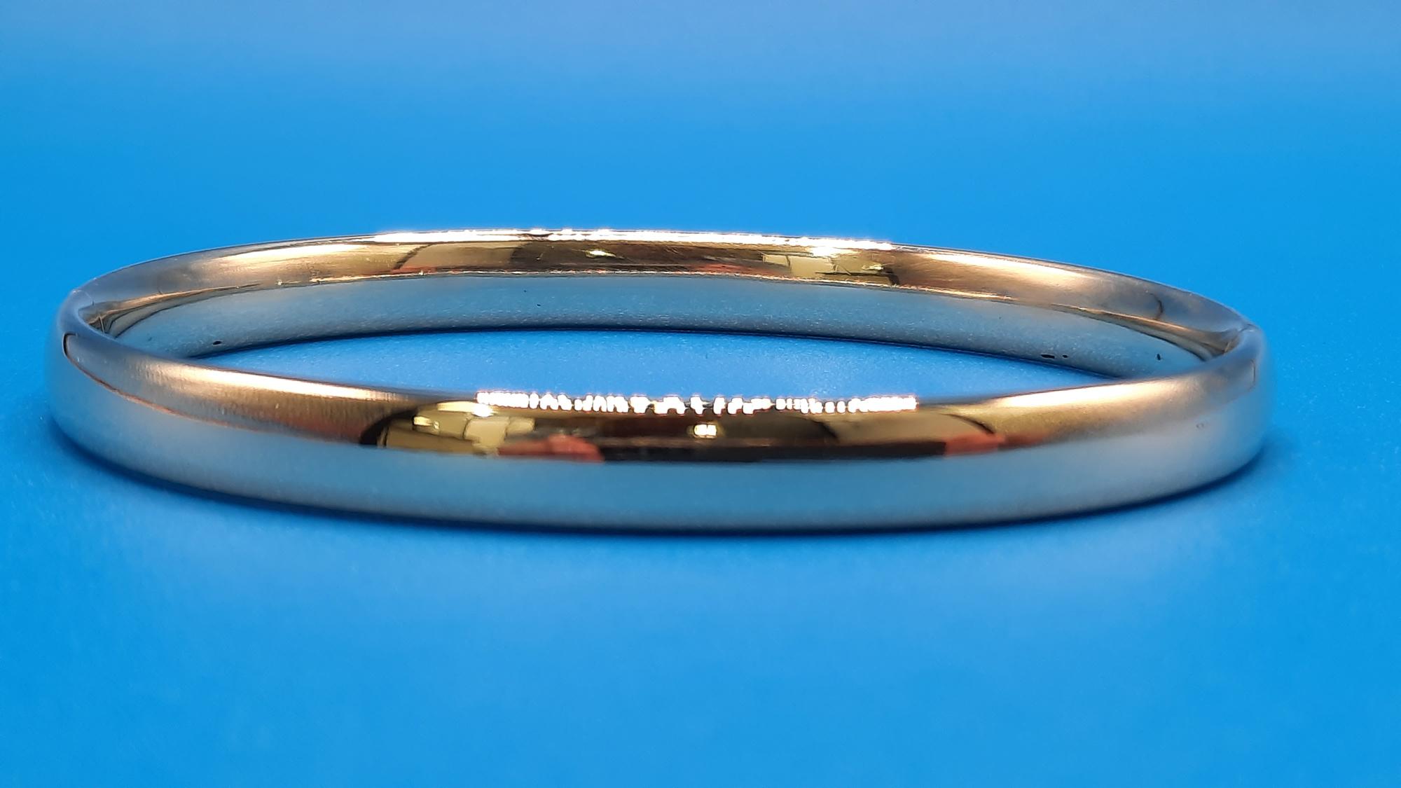 De gouden armband 14kt, modelnummer 0002295, is een stijlvol sieraad met een diameter van 60 mm en een breedte van 6,3 mm. Gemaakt van goud met een karaatgewicht van 14kt, past deze goudkleurige armband perfect bij elke gelegenheid. Draag hem alleen voor een subtiele look of combineer met andere armbanden voor een gelaagd effect.