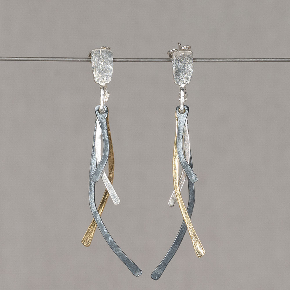 Oorstekers gemaakt van 925 sterling zilver, geoxideerd zilver en zilver verguld. De oorstekers bestaan uit 4 losse elementen die op verschillende hoogtes achter elkaar hangen. Hierdoor bewegen deze oorstekers soepel heen en weer.