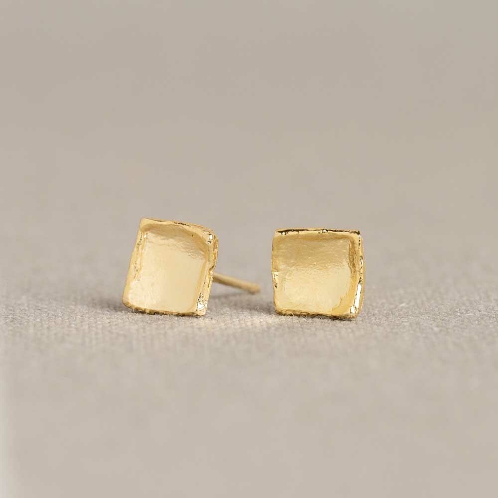 Oorstekers gemaakt van zilver verguld en hebben een vierkante vorm. Doordat de vierkantjes gebogen zijn wordt er een driedimensionaal effect gecreëerd.