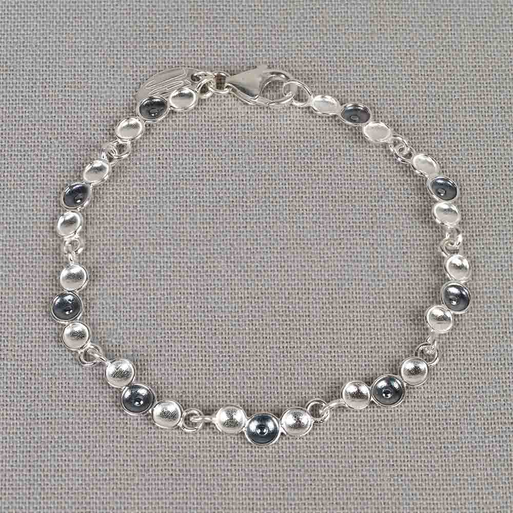 Deze armband is gemaakt van 925 sterling zilver en geoxideerd zilver. De armband bevat schakels bestaande uit drie druppels, waarvan de middelste geoxideerd is. Combineer met het bijpassende collier en de bijpassende oorbellen voor een complete look!