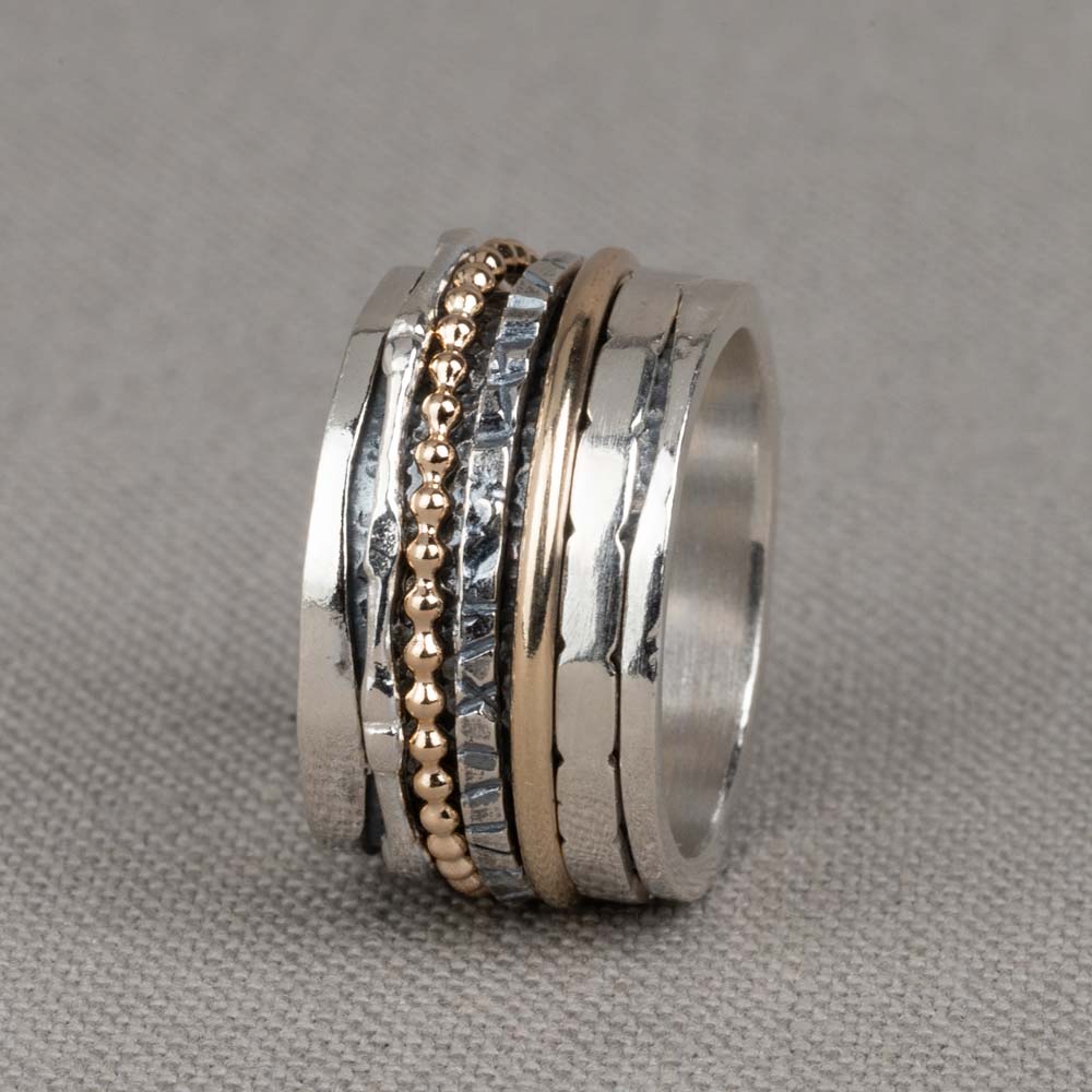Bijzondere ring gemaakt van (geoxideerd) 925 sterling zilver en gold filled. De ringen in het midden van de ring kunnen bewegen, dit zorgt voor een speels effect. Onder de ring is gebruik gemaakt van geoxideerd zilver. Doordat de ringen speels bewegen, is het mogelijk dat de geoxideerde laag na verloop van tijd vervaagd. De glans van 925 sterling zilver maakt het een gewild edelmetaal voor de vervaardiging van sieraden. Het bestaat uit 92,5% puur zilver en 7,5% koper. Puur zilver is een zacht en buigzaam materiaal, het koper in 925 sterling zilver zorgt voor de stevigheid. De sieraden van Jeh Jewels zijn nikkel vrij. Gold filled komt uit Amerika en wordt daar al langer gebruikt voor de vervaardiging van sieraden met een "touch of gold" voor een betaalbare prijs. Het gold filled blijft op kleur, is slijtvast en de 14karaats goudlaag is dik genoeg om lang te kunnen genieten van de warme uitstraling van goud. Gold filled wordt veelal ook goed verdragen door mensen die allergisch zijn voor andere metalen dan goud.
