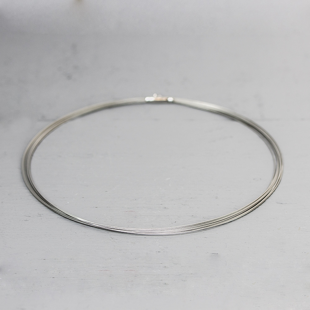 Basiscollier in de vorm van een spang, bestaande uit 10 draden. Materiaal: Edelstaal