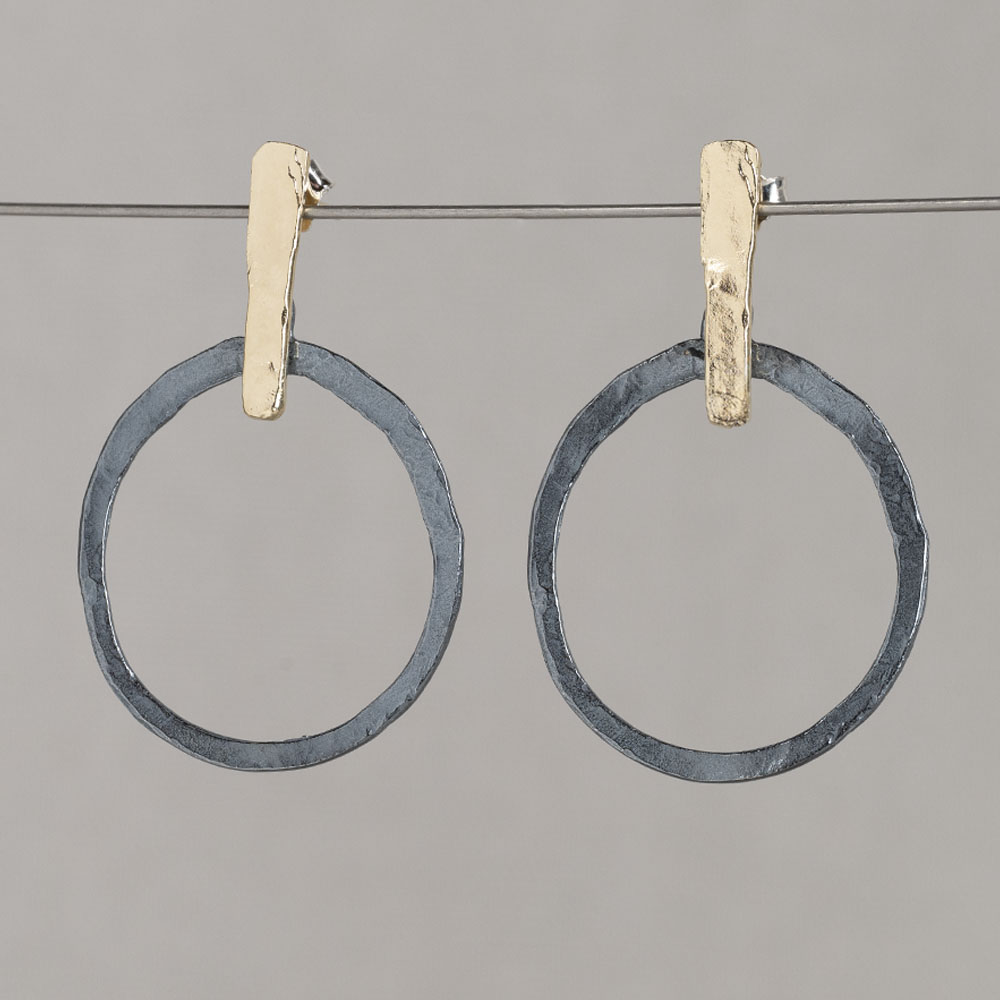 Oorsteker gemaakt van zilver geoxideerd en zilver verguld in de vorm van een staafje met een open circel.