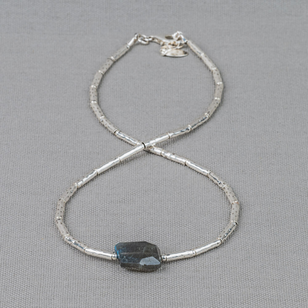 Collier gemaakt van 925 sterling zilveren buisjes in combinatie met de edelsteen Labradoriet. Labradoriet is een magische, beschermende en spirituele steen. Het beschermt het eigen energieveld (aura) tegen negatieve invloeden uit de omgeving. Wanneer je de steen beweegt/draait, komen de kleuren van de regenboog tevoorschijn. Combineer met de andere sieraden van Jeh Jewels.