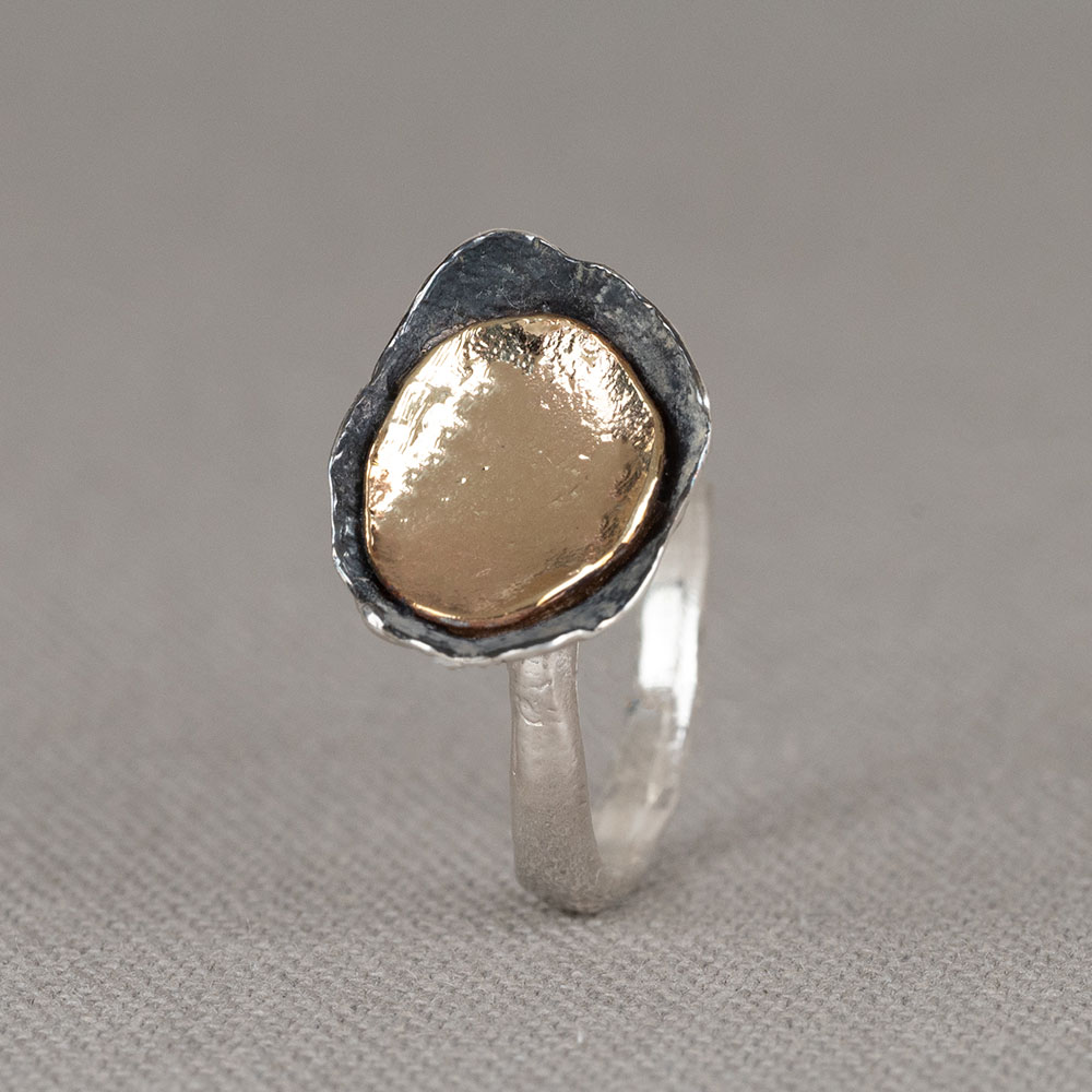 Ring gemaakt van 925 sterling zilver met daarop een schaaltje van geoxideerd zilver en 9 karaat. Draag deze ring in combinatie met de bijpassende oorbellen en het bijpassende collier voor een complete look!