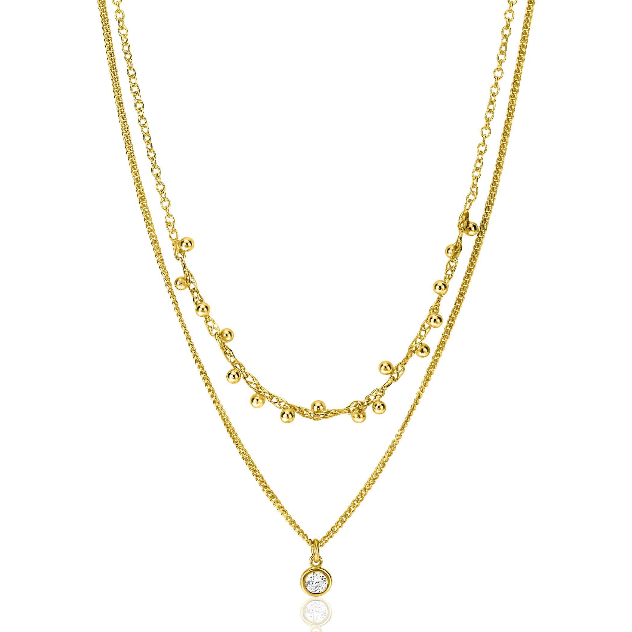 ZINZI gold plated zilveren multilook ketting met twee verschillende schakels: een subtiele gourmet schakel en een mooie jasseron schakel met 16 bolletjes. Een mooie ronde zetting (5,5 mm) met witte zirconia hangt sierlijk aan de gourmet ketting. De lengte van deze bovenste ketting is te variëren tussen 39 en 42 cm. Met herkenbaar Zinzi hartje bij de sluiting. De ketting is vervaardigd van eerste gehalte zilver (925) en voorzien van een extra geel vergulding.