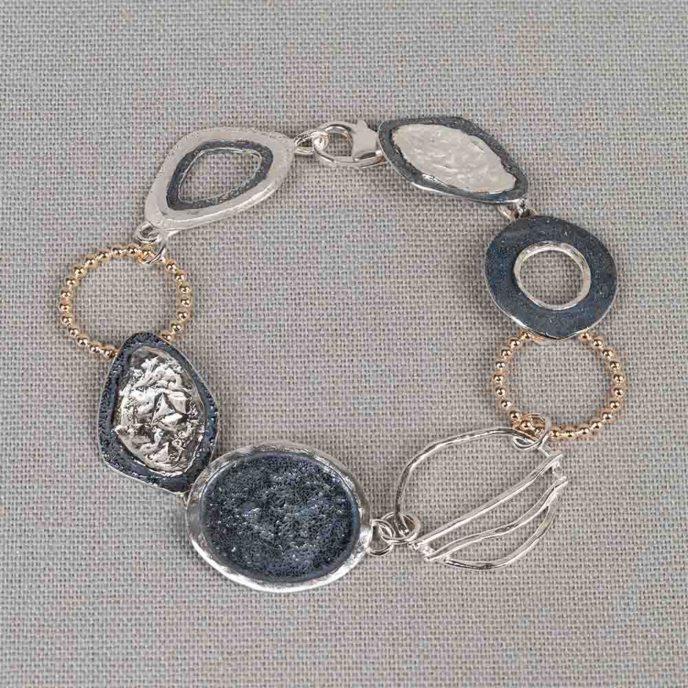 Armband gemaakt van 925 sterling zilver, geoxideerd zilver en Goldfilled. Deze armband bestaat uit verschillende organische vormen, wisselend van materiaal wat hem daardoor 3 kleuren geeft. Draag met het bijpassende collier voor een complete look!