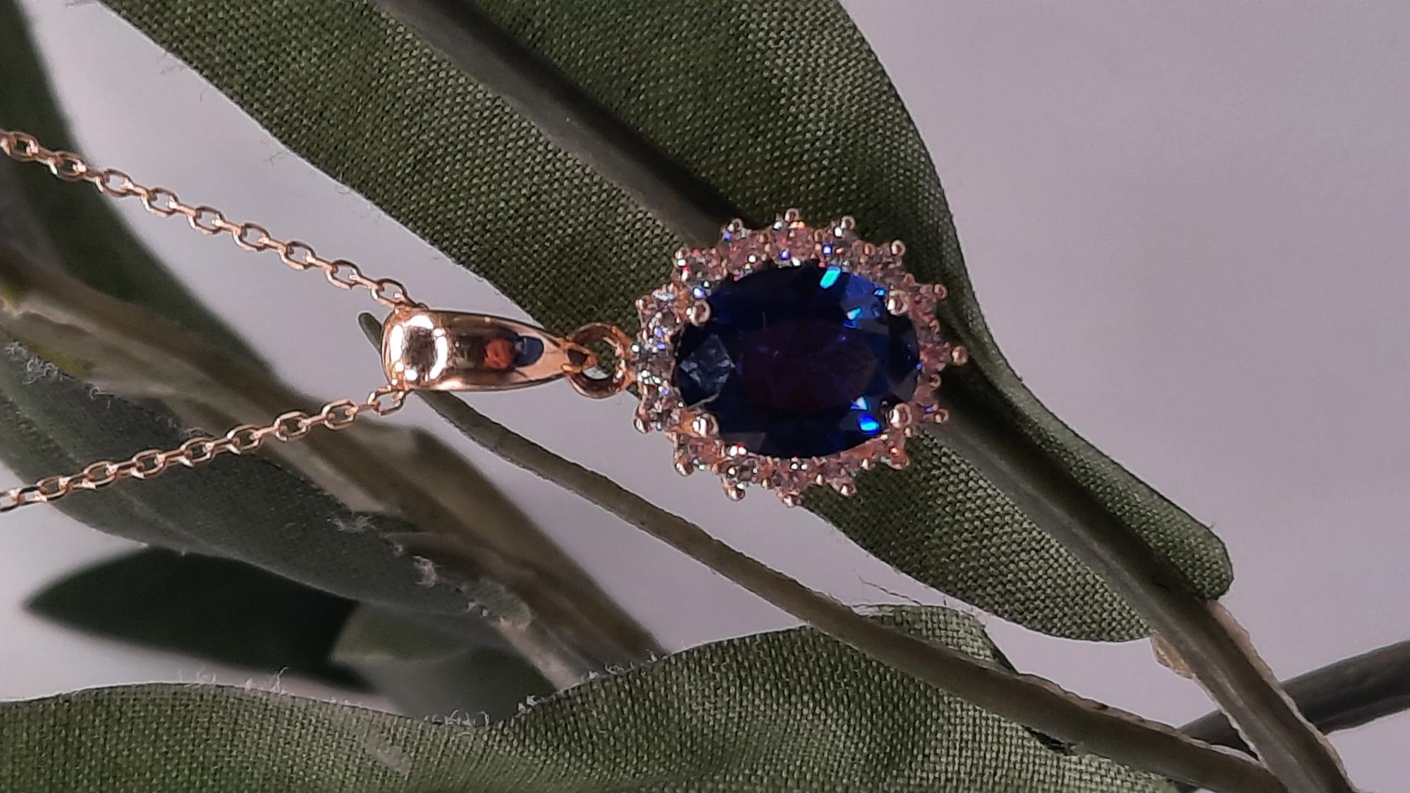 Deze prachtige gouden hanger, model 0002432, is gemaakt van 14-karaats goud en heeft een diameter van 14 mm en een breedte van 11 mm. De hanger is bezet met zirkonia en een saffier. Een perfecte toevoeging aan een gouden ketting voor een elegante en tijdloze uitstraling. Draag hem solo voor een verfijnde look.