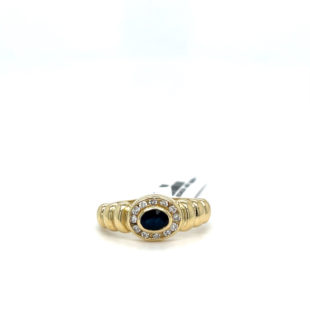 Occasion gouden ring met een prachtige diep blauwe saffier en rondom gezet met briljant in een railzetting