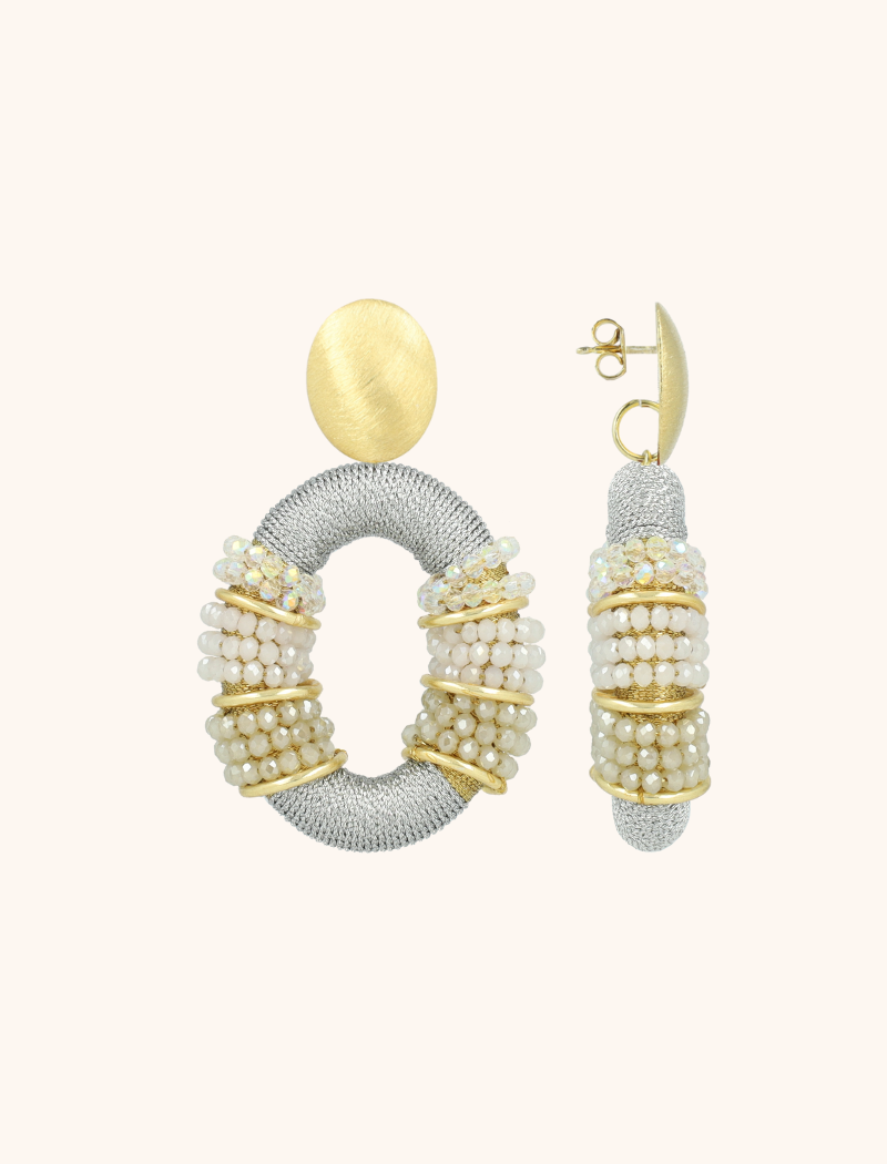 Voeg een vleugje sprankeling toe aan je look met de 'Crystal Silver/Nude Oorbellen Elle Combi Oval Deluxe L'. Deze prachtige oorbellen stralen verfijning uit met hun subtiele glaskralen in een unieke kleurencombinatie. Het lichte ontwerp zorgt voor ultiem draagcomfort, waardoor ze ideaal zijn voor elke gelegenheid. Ontdek de magie van LOTT. gioielli.