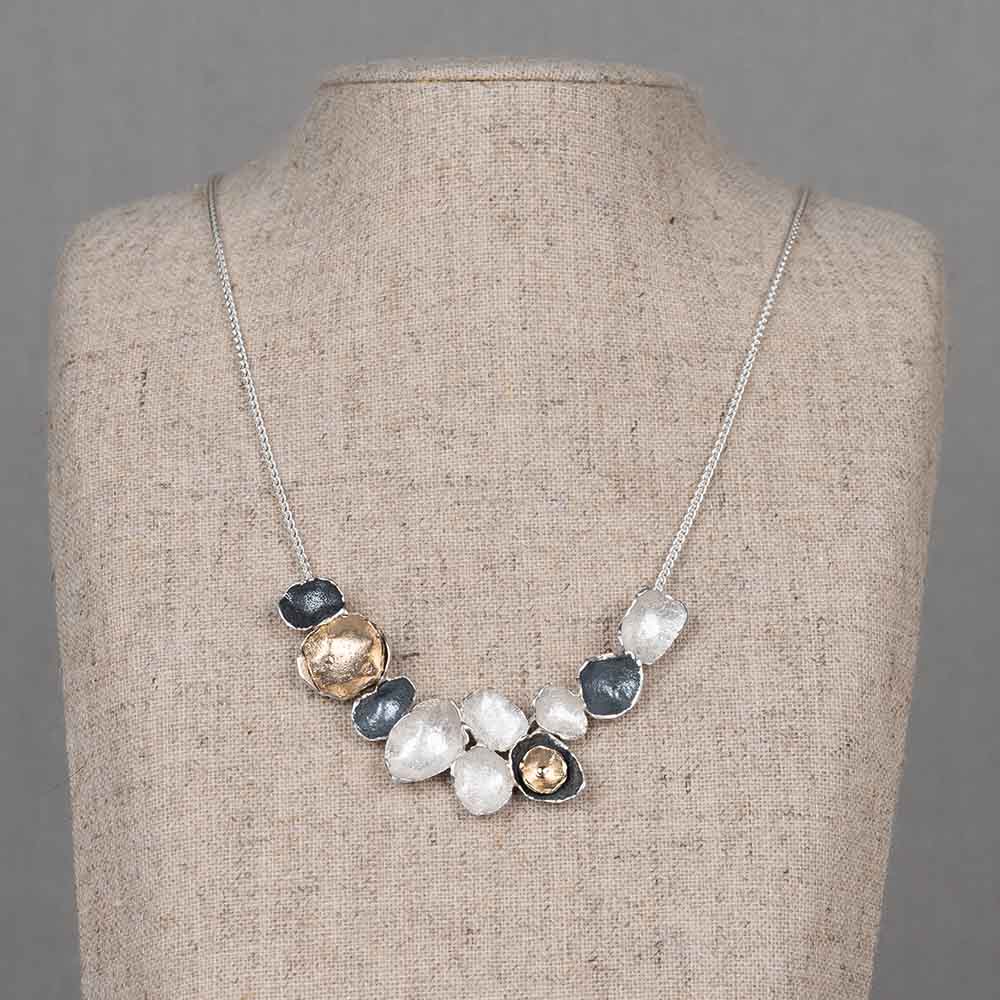 Collier gemaakt van 925 sterling zilver, geoxideerd zilver en zilver verguld. Dit collier bestaat uit een zilvere basis met daaraan een boog van schakels in de drie verschillende soorten zilver.