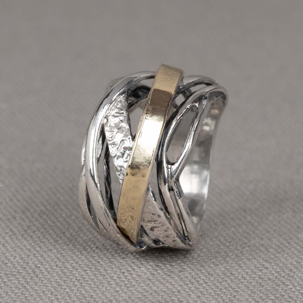 Ring gemaakt van 925 sterling zilver, geoxideerd zilver en 9 karaat. Deze ring is anders dan de gebruikelijke ringen, in plaats van bewegende bandjes heeft deze ring bogen.