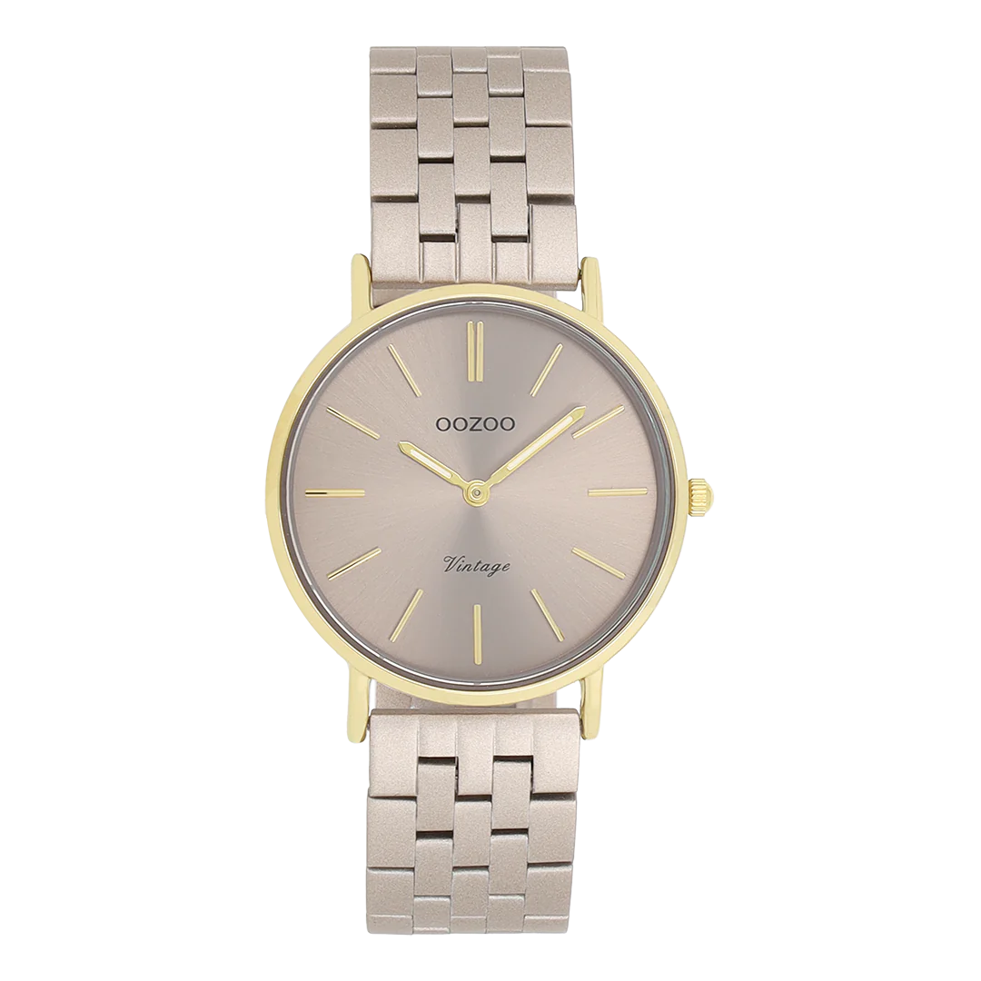 De Oozoo horloge C20409 is een stijlvolle damespolshorloge. Het heeft een goudkleurige, ronde metalen kast en een taupe roestvrijstalen band. De wijzerplaat is analoog met strepenindex in taupe kleur. Nikkelvrij en zonder datumaanduiding. Perfect voor zowel casual als formele gelegenheden, past mooi bij neutrale en aardetinten voor een elegante look.