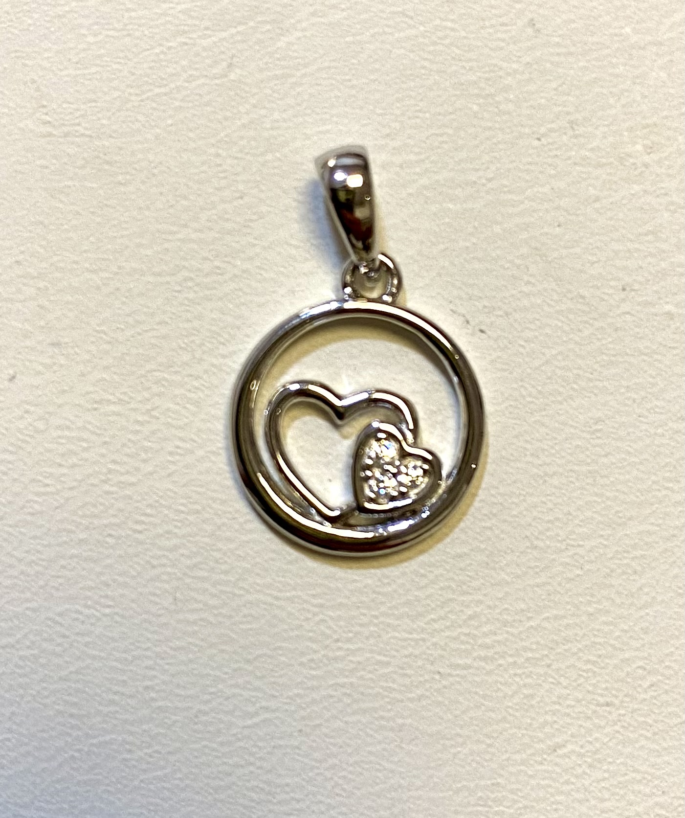 Gerhodineerd 925 zilveren hanger uitgevoerd met twee hartjes en een schitterend zirkonia vlak. De hanger heeft een totale hoogte van 1.8cm en een diameter van 12mm.