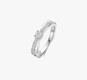 Laat je betoveren door de tijdloze schoonheid van deze TI SENTO pavé zilveren ring 12374. Ontworpen met twee verstrengelde banden, symboliseert dit stuk eenheid en verfijning. Eén band is voorzien van een stralende pavé van witte zirkonia stenen, terwijl de andere schittert met glad, gepolijst zilver verguld met stralend platina. Dit harmonieuze ontwerp viert de perfecte balans tussen schittering en eenvoud, waardoor het een veelzijdig accessoire is voor elke gelegenheid. Of je nu een speciale mijlpaal viert of een vleugje elegantie toevoegt aan je dagelijkse stijl, deze ring is een moeiteloos statement van verfijning. Zoals alle TI SENTO sieraden, is deze ring hypoallergeen en vervaardigd met de beste materialen om blijvende schoonheid en comfort te garanderen.