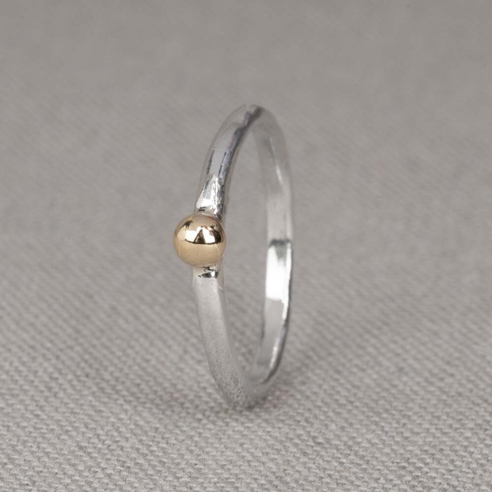 Ring aus der Herbstkollektion 2022 Jeh Jewels aus Silber und 9 Karat. Dieser Ring ist eine Kombination aus 925er Sterlingsilber mit einer 9-Karat-Kugel an der Spitze. Schön kombinierbar mit den anderen Ringen aus der neuen Herbstkollektion. Material: 925er Sterlingsilber Die Brillanz von 925er Sterlingsilber macht es zu einem begehrten Edelmetall für die Schmuckherstellung. Es besteht zu 92,5 % aus reinem Silber und zu 7,5 % aus Kupfer. Reines Silber ist ein weiches und flexibles Material, das Kupfer in 925er Sterlingsilber sorgt für die Festigkeit. Der Schmuck von Jéh Jewels ist nickelfrei. Material: 9 Karat Der Begriff Karat gibt an, wie viel reines Gold pro Tausend Teile in einem Schmuckstück steckt. Je höher dieser Wert, desto mehr Gold. In einem 9 Karat Schmuckstück stecken 337,5 Teile Gold.