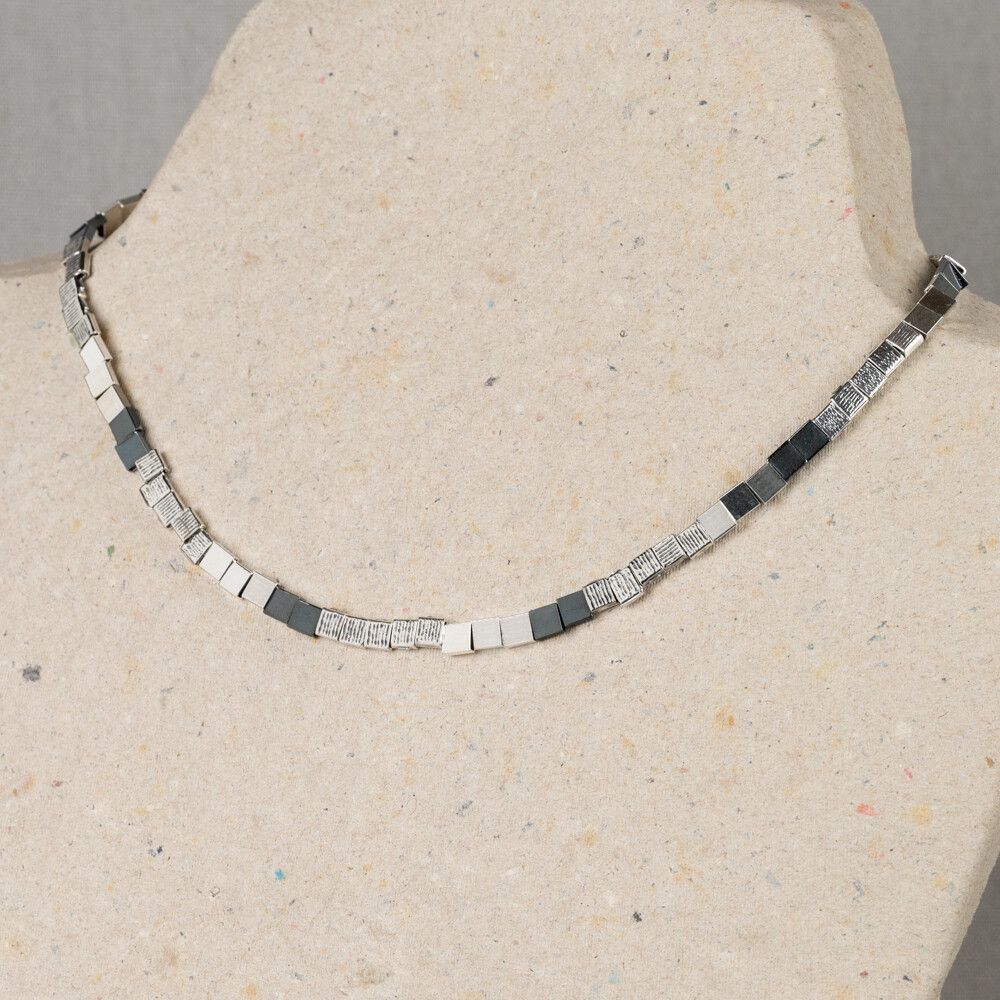 Collier uit de Silver-collectie van Jéh Jewels, gemaakt van 925 sterling zilver en geoxideerd zilver, 45 cm. Het collier bestaat uit vierkante blokjes met ieder een eigen structuur. Combineer dit collier met het bijpassende armband van Jéh Jewels.   