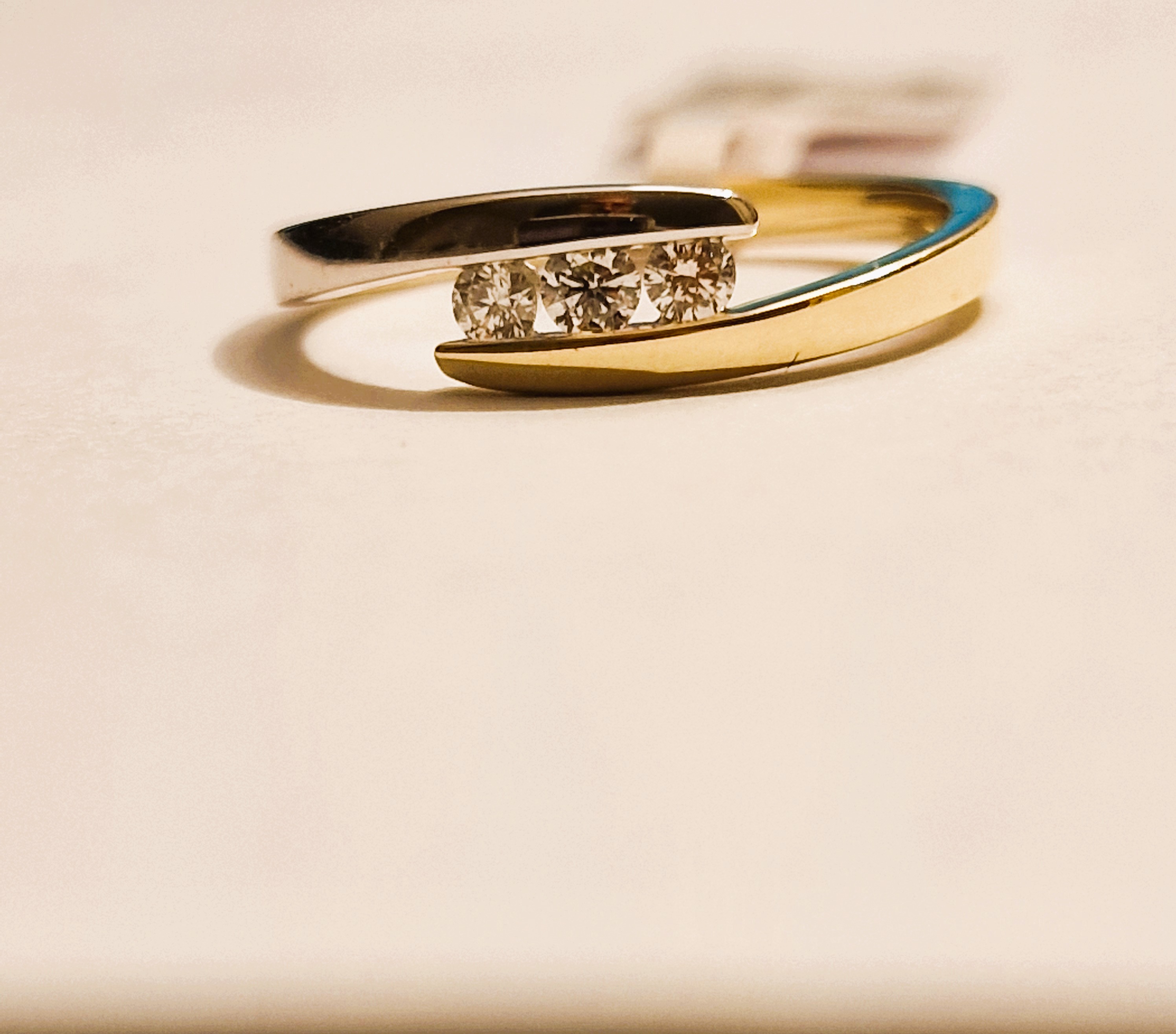 14k geel en witgouden slagring met 3 diamanten gezet in een railzetting