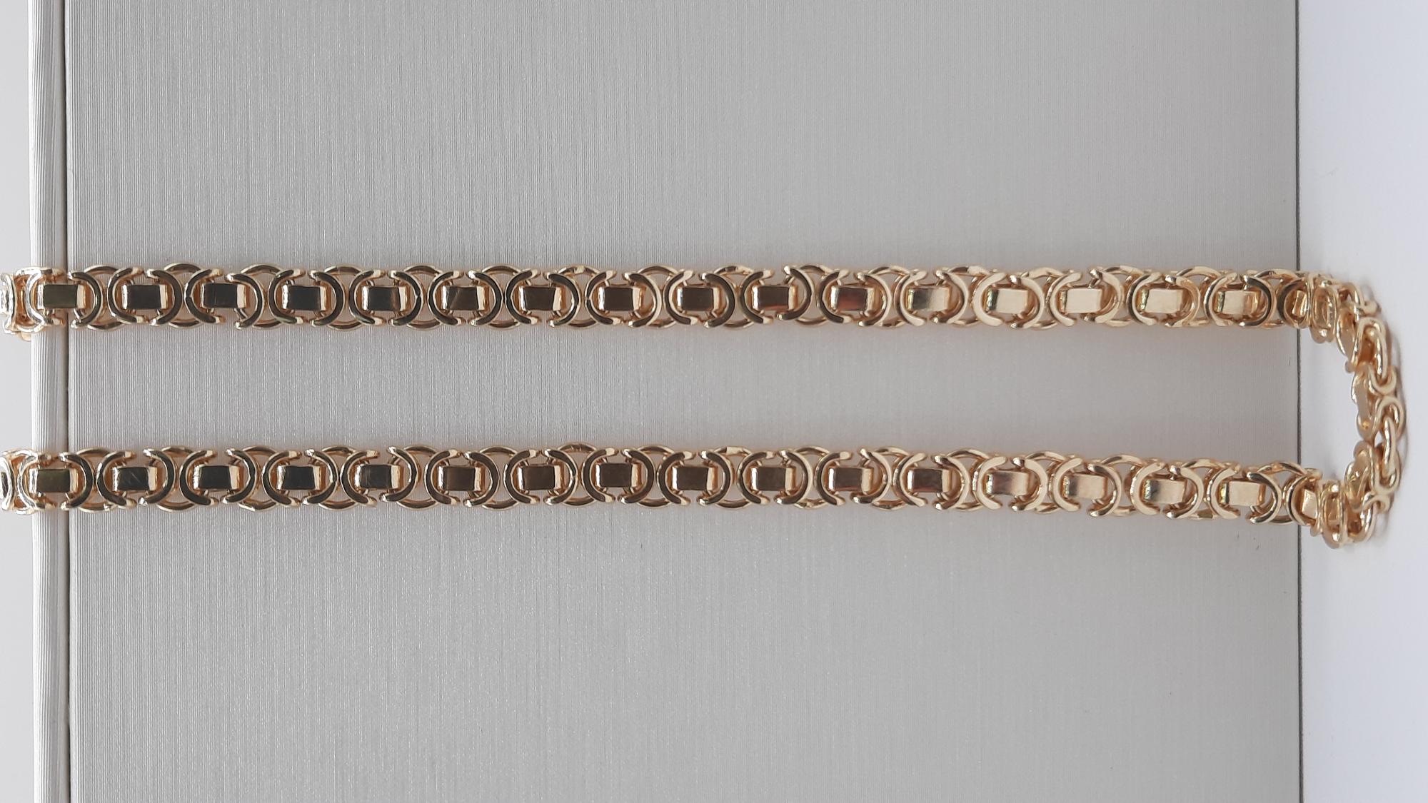 De gouden platte koningsketting model 0002274 is een prachtige ketting met de volgende kenmerken: gemaakt van 14 karaats goud, een lengte van 60 cm, een breedte van 5,2 mm en een gewicht van 38,6 gram. Draag deze elegante ketting solo voor een verfijnde look of combineer met andere sieraden voor extra allure.