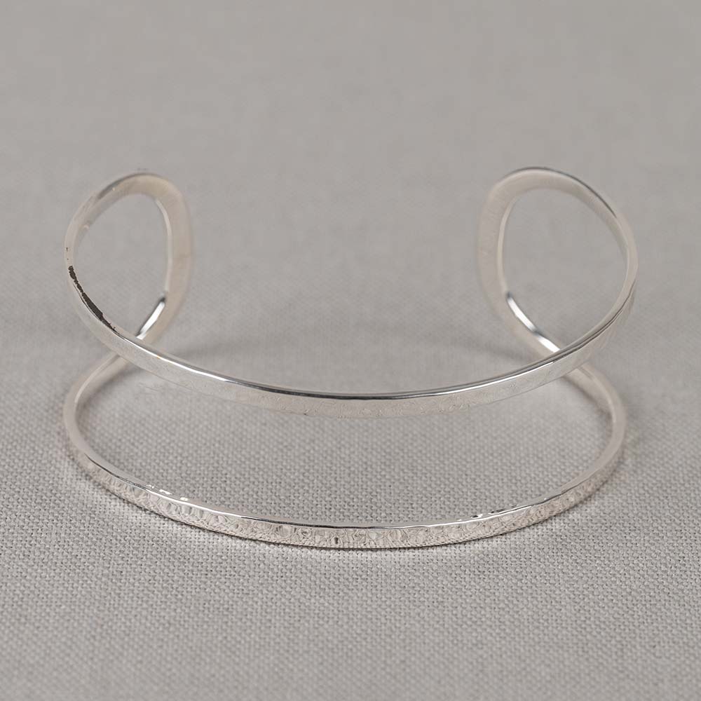 De Jeh zilveren klemband met dubbele hamerslag, modelnummer 21606, is een elegante armband gemaakt van hoogwaardig zilver. Met een unieke hamerslag afwerking straalt het vakmanschap en stijl uit. Ideaal voor zowel dagelijkse als formele gelegenheden. Combineer met andere zilveren accessoires voor een verfijnde look. Deze veelzijdige armband voegt een verfijnd accent toe aan elke outfit.