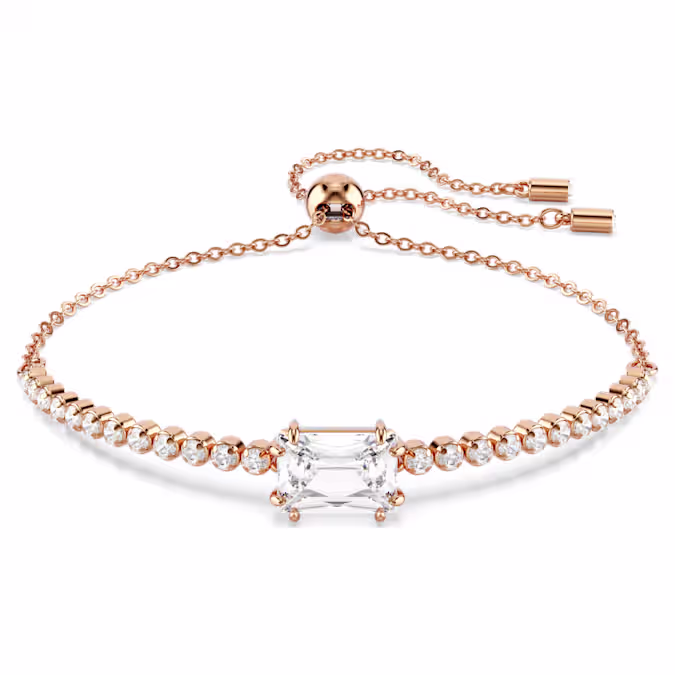 Deze klassieke Tennis-armband voegt een vleugje glans toe aan elke look. Het ontwerp met roségoudkleurige toplaag en schuifsluiting voor een verstelbare pasvorm heeft een gelijkmatige rij Swarovski Zirkonia en wordt geaccentueerd door een Swarovski Zirkonia in baguette-slijpvorm in het midden. Hiermee geeft u een levendige draai aan een tijdloze stijl die u keer op keer kunt dragen.