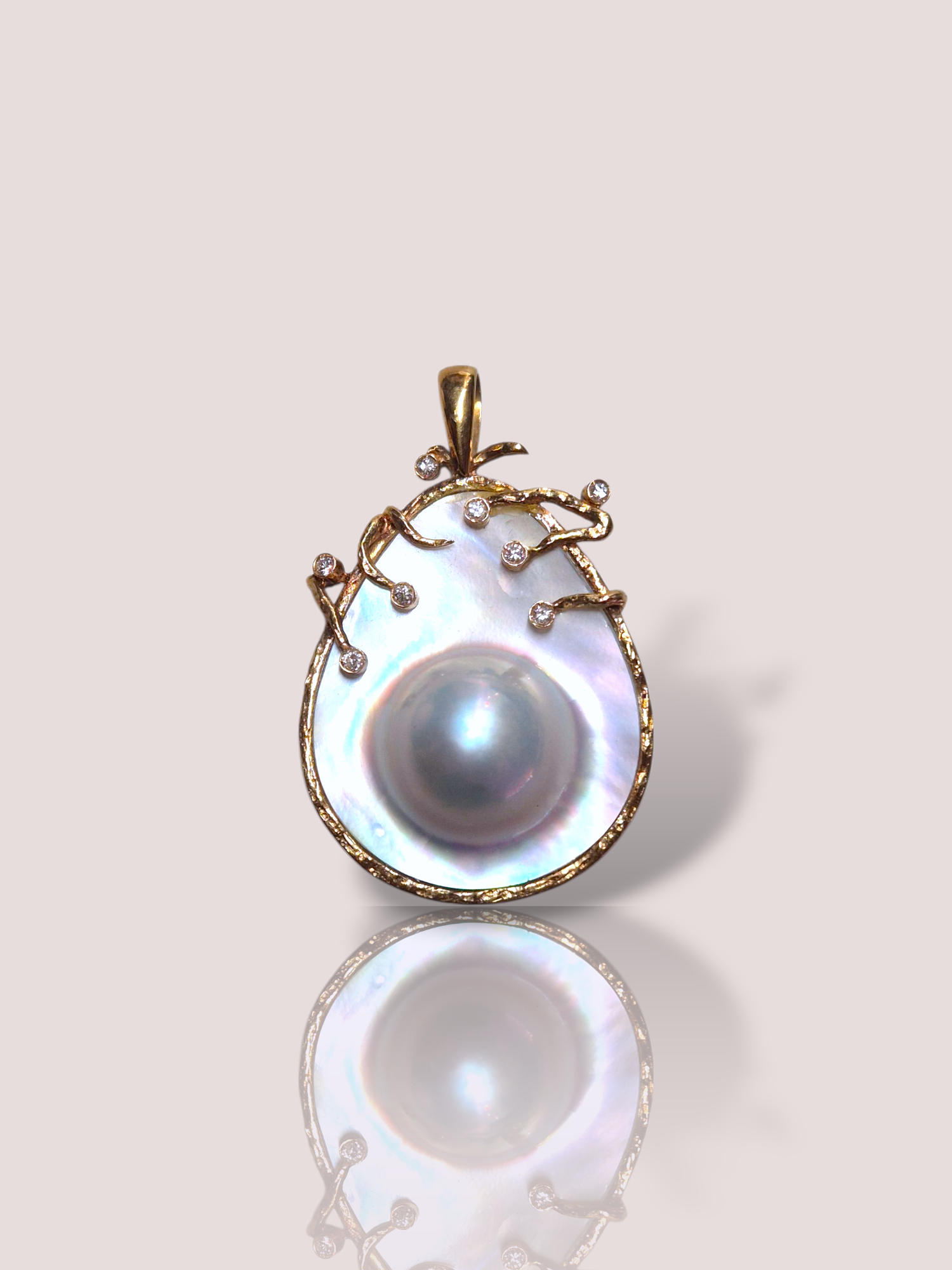 Deze vintage 14k geel gouden mabé parel hanger bevat een prachtige mabé parel omringd door schitterende diamanten en bewerkt geel goud. Een prachtige hanger met een luxueuze uitstraling. De hanger heeft een formaat van 4 x 3 cm. 

Draag deze elegante hanger op een subtiele gouden ketting om elke outfit een klassieke en verfijnde uitstraling te geven. Perfect voor speciale gelegenheden.